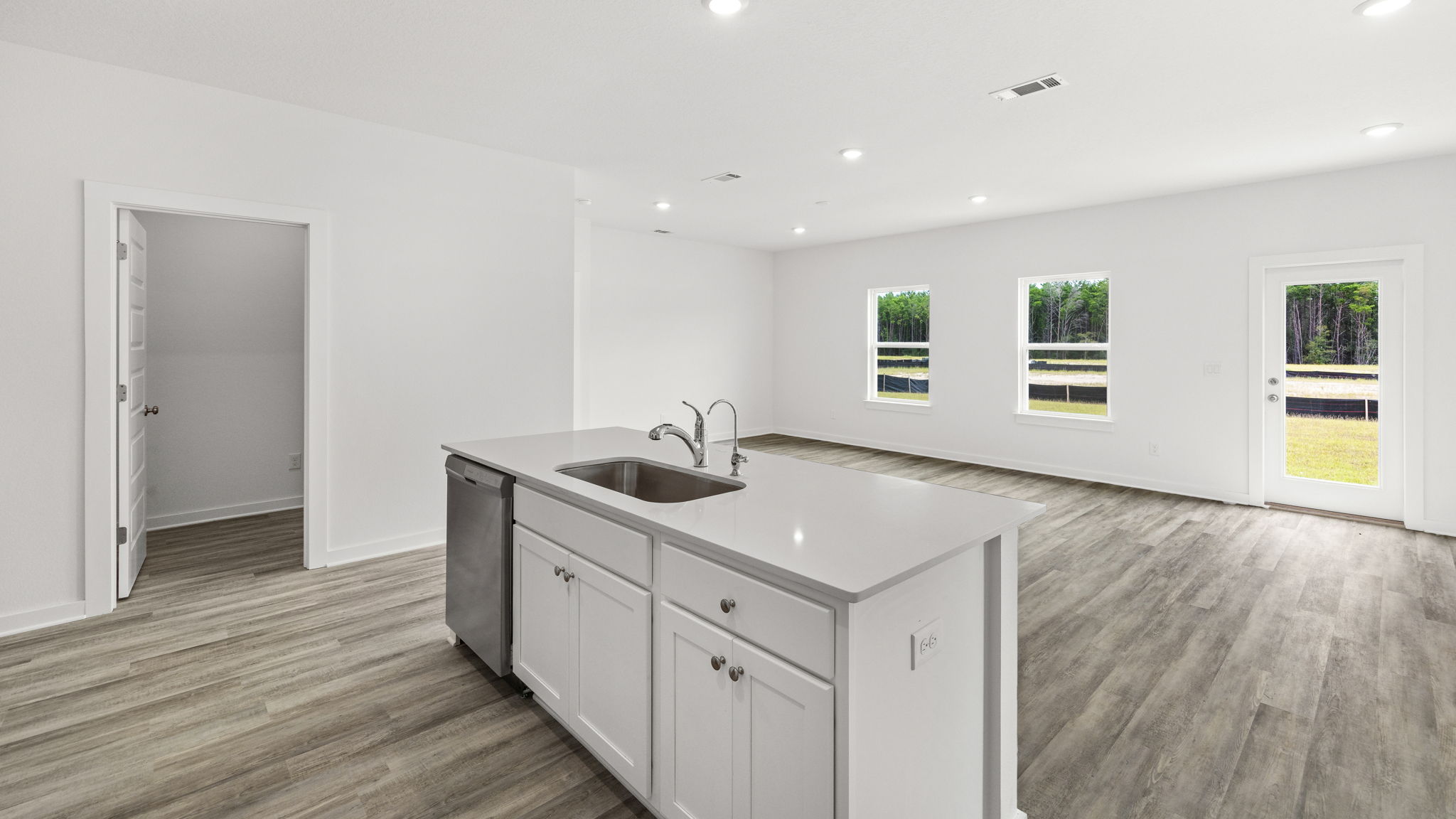 The kitchen island has a sink and dishwasher and lower cabinetry for storage
