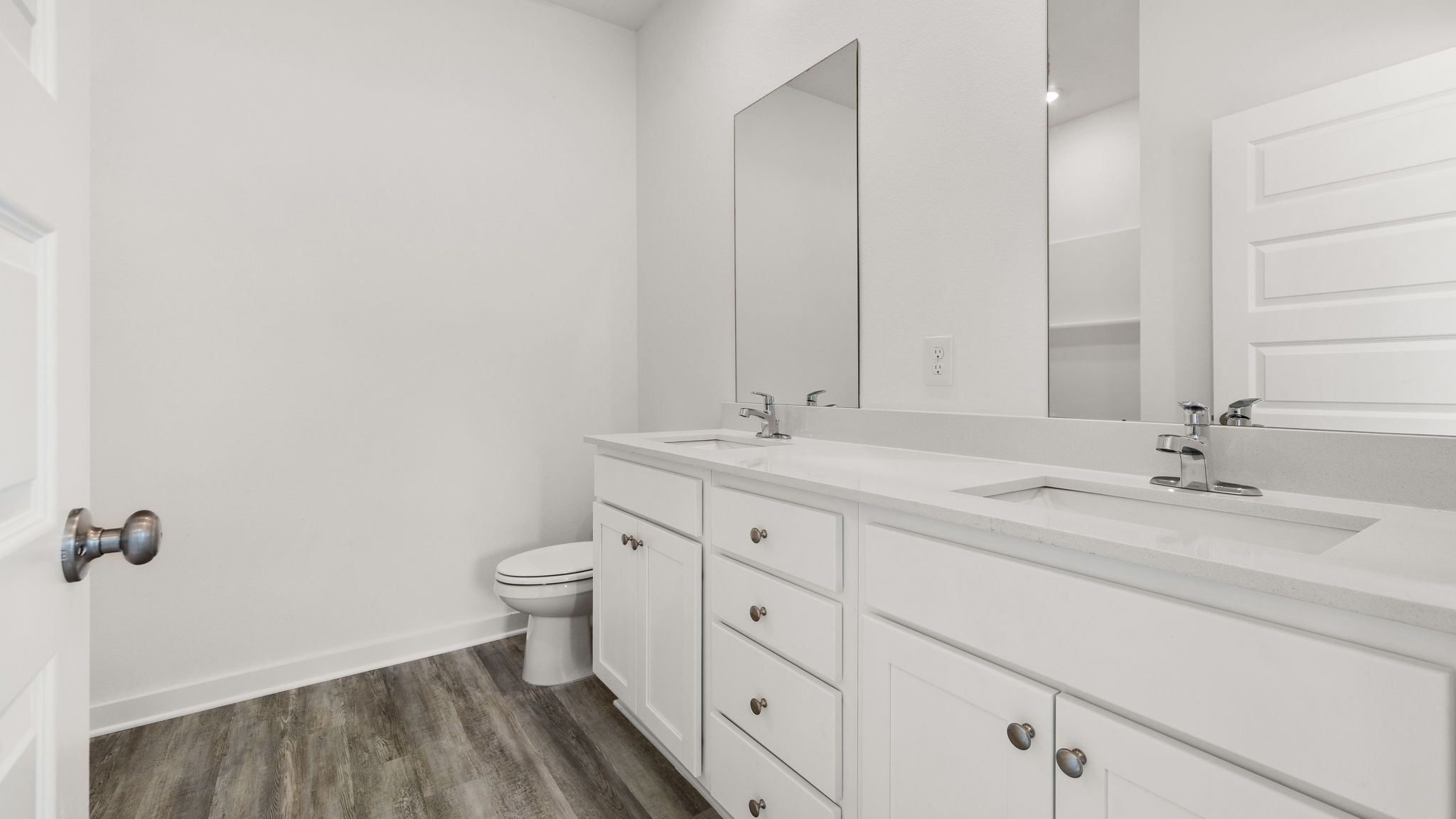The primary bathroom has a dual sink vanity with lower cabinetry and drawers for storage