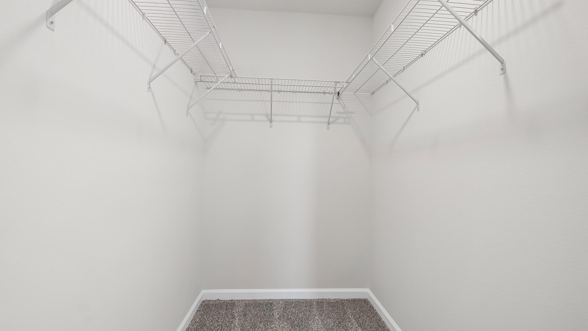 The closet in primary bedroom has ventilated shelving