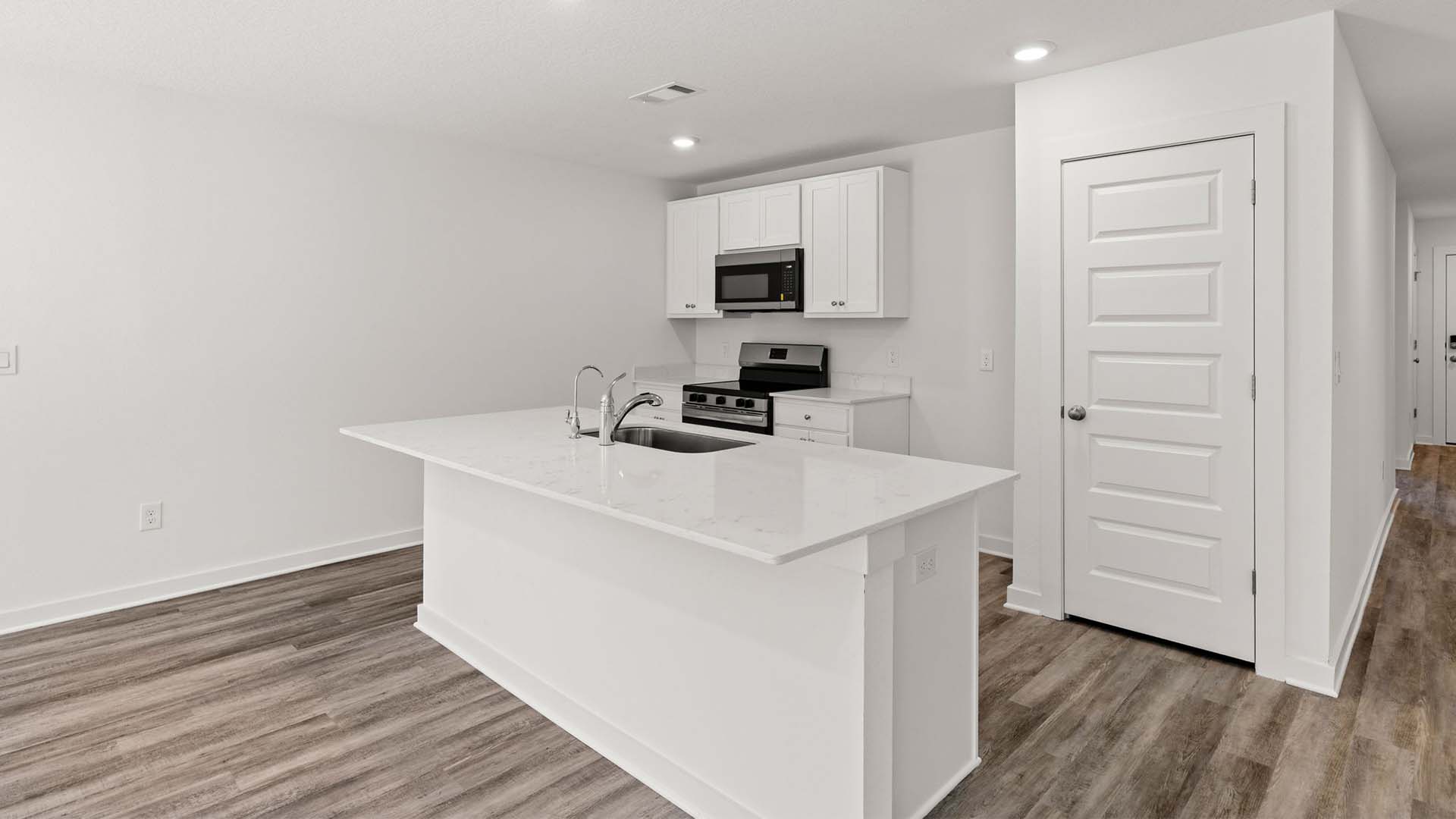 The kitchen has a pantry and upper and lower cabinetry for storage
