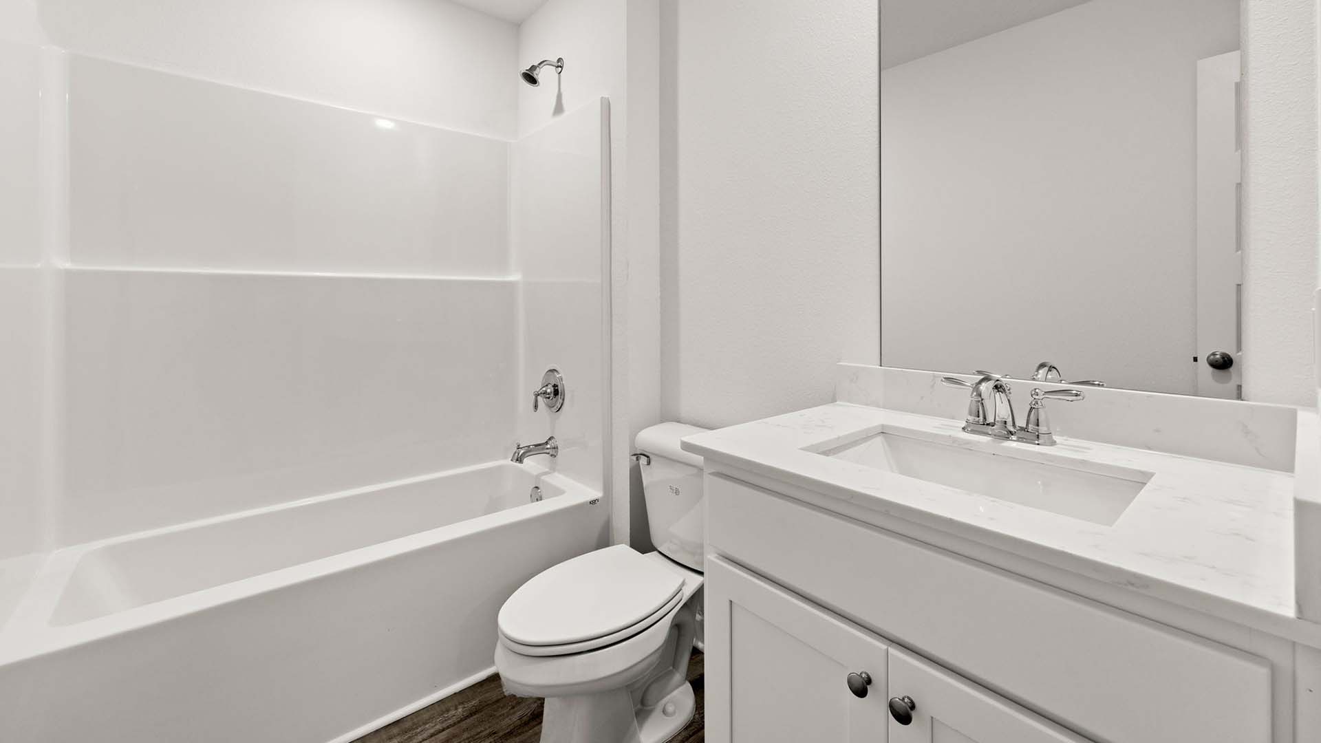 Shared bathroom with single vanity and lower cabinetry for storage with quartz countertops