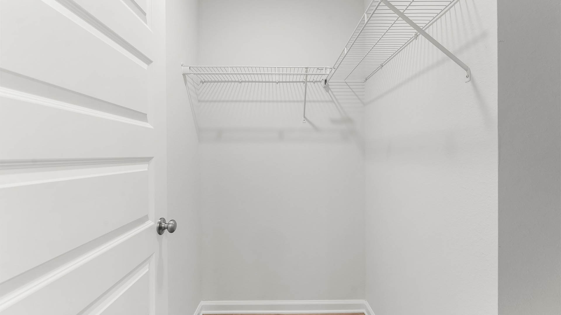 Primary closet is spacious and features upper shelving