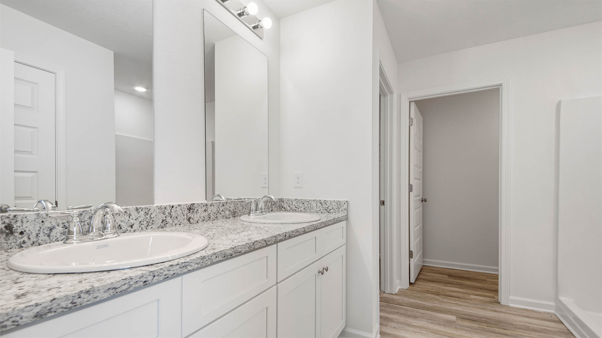 Primary bathroom with dual sink vanity and granite countertop