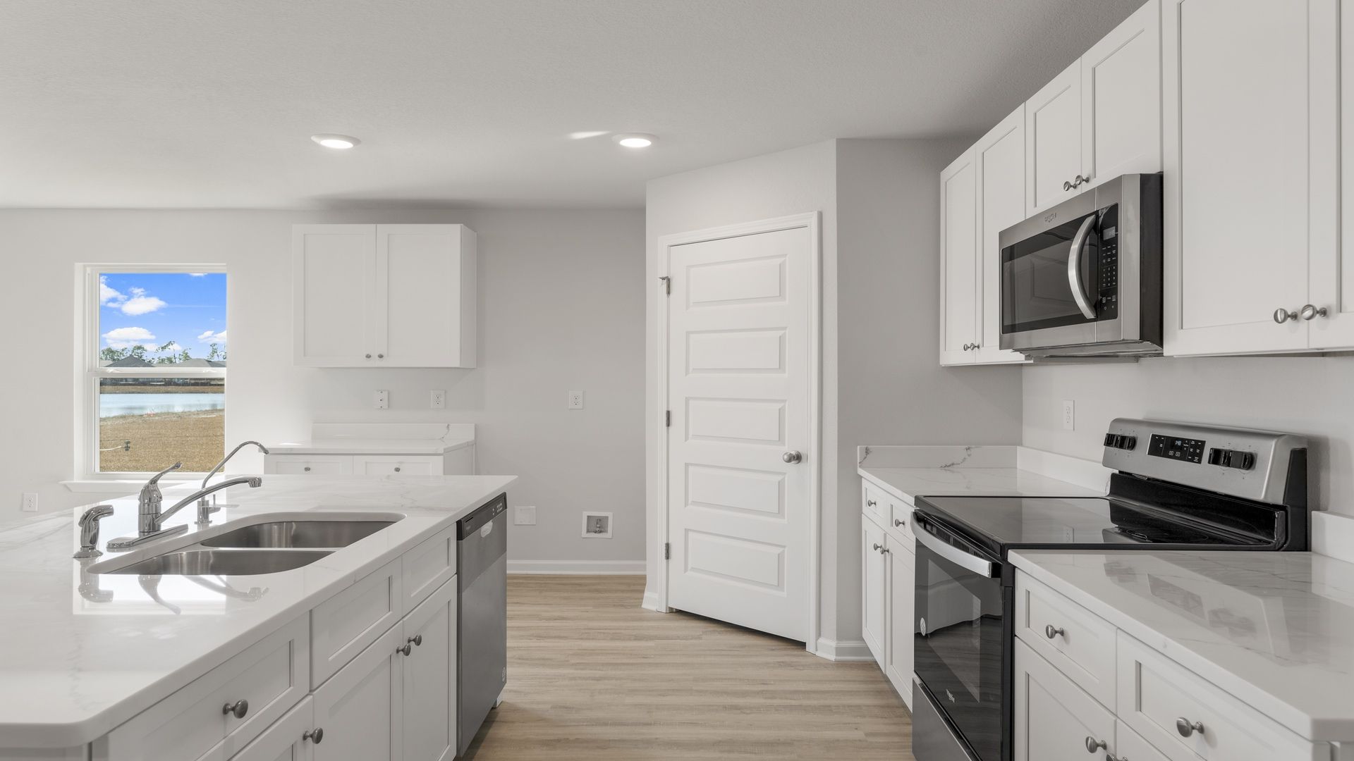 The kitchen has quartz countertops and upper and lower cabinetry for storage
