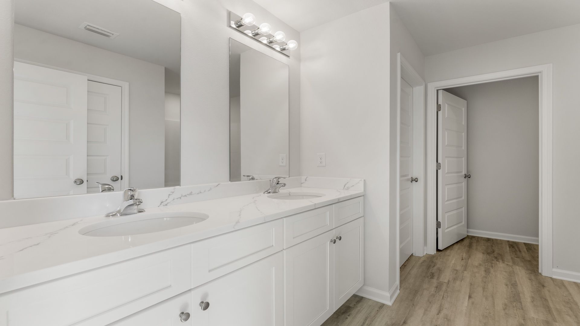 The primary bathroom has a dual sink vanity with lower cabinetry for storage