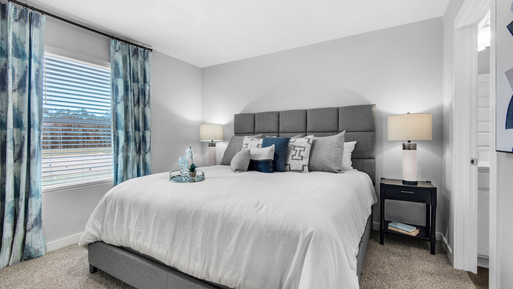 The primary bedroom in this image is staged with a king size bed