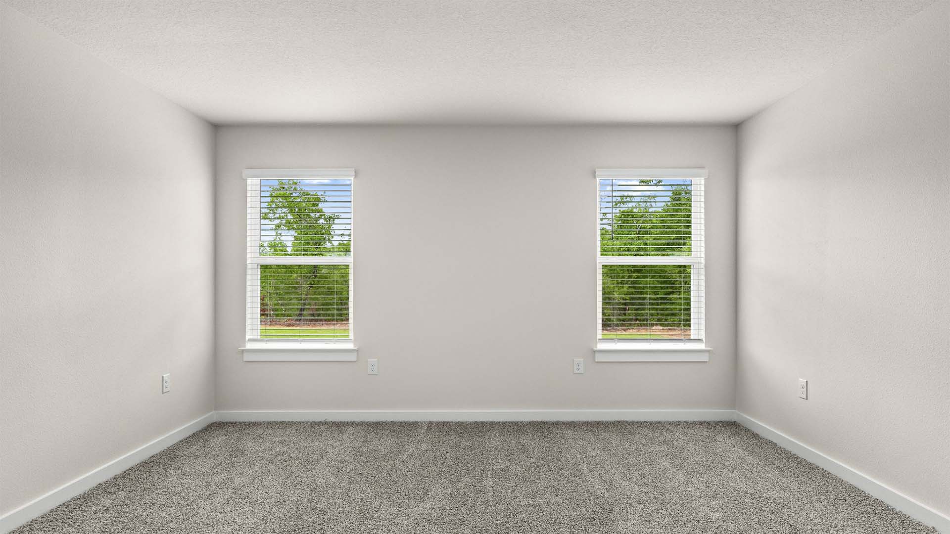 The primary bedroom has windows allowing for natural light