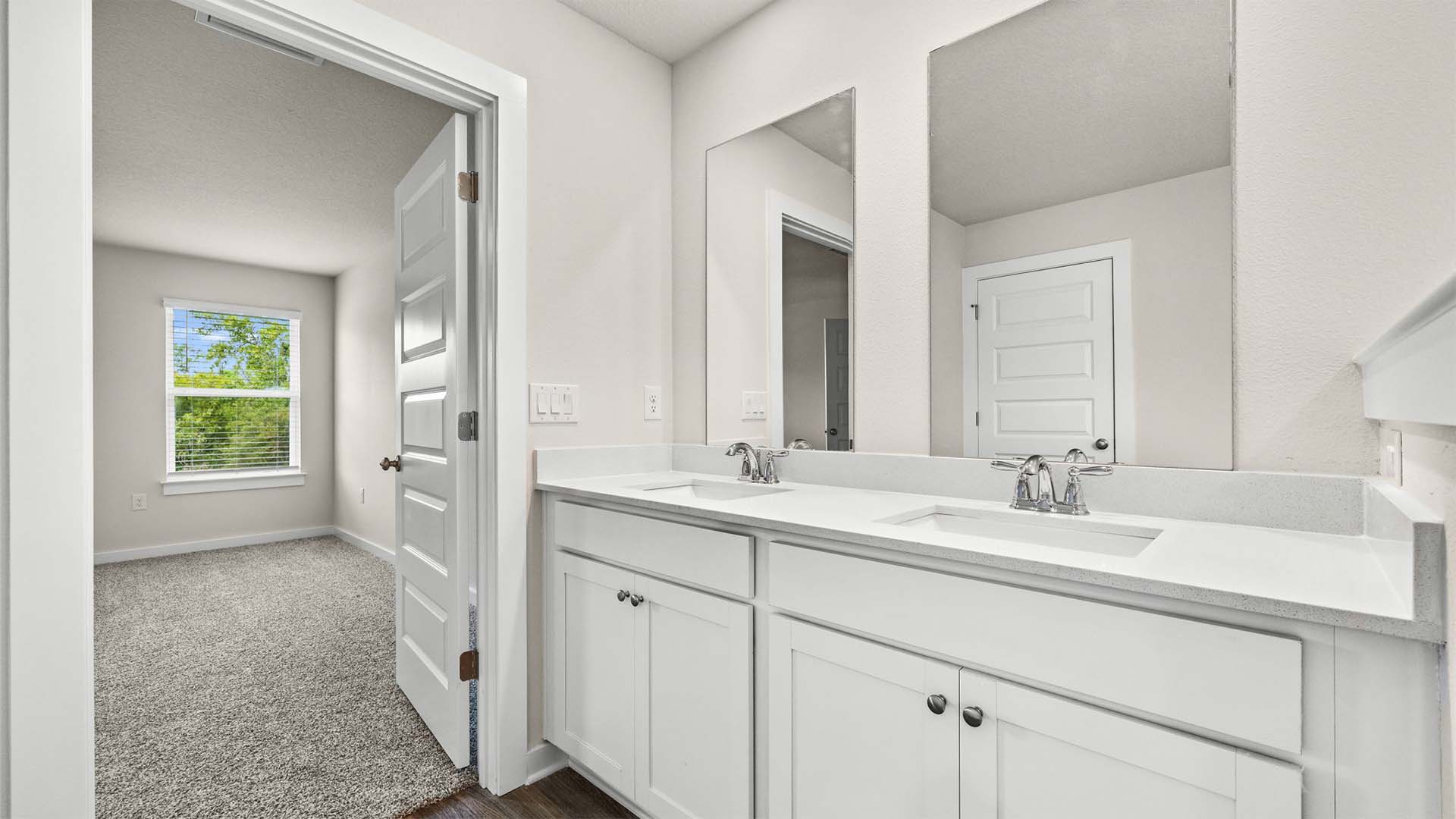 The primary bathroom has a dual sink vanity and lower cabinetry for storage
