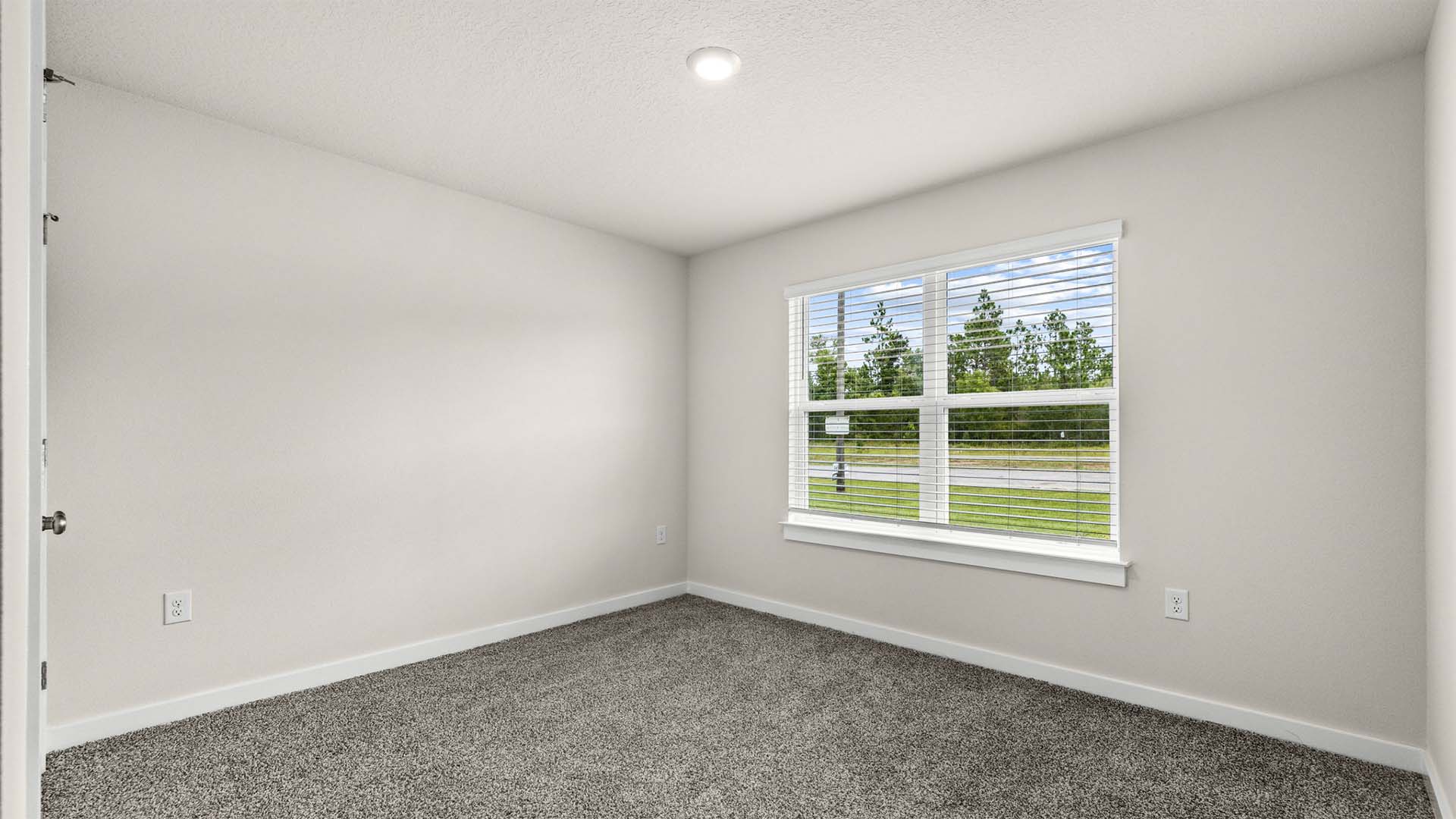 One of the guest bedrooms is at the front of the home with a large picture window