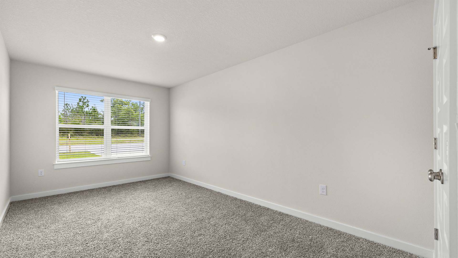 A second guest bedroom is located at the front of the home with a picture window