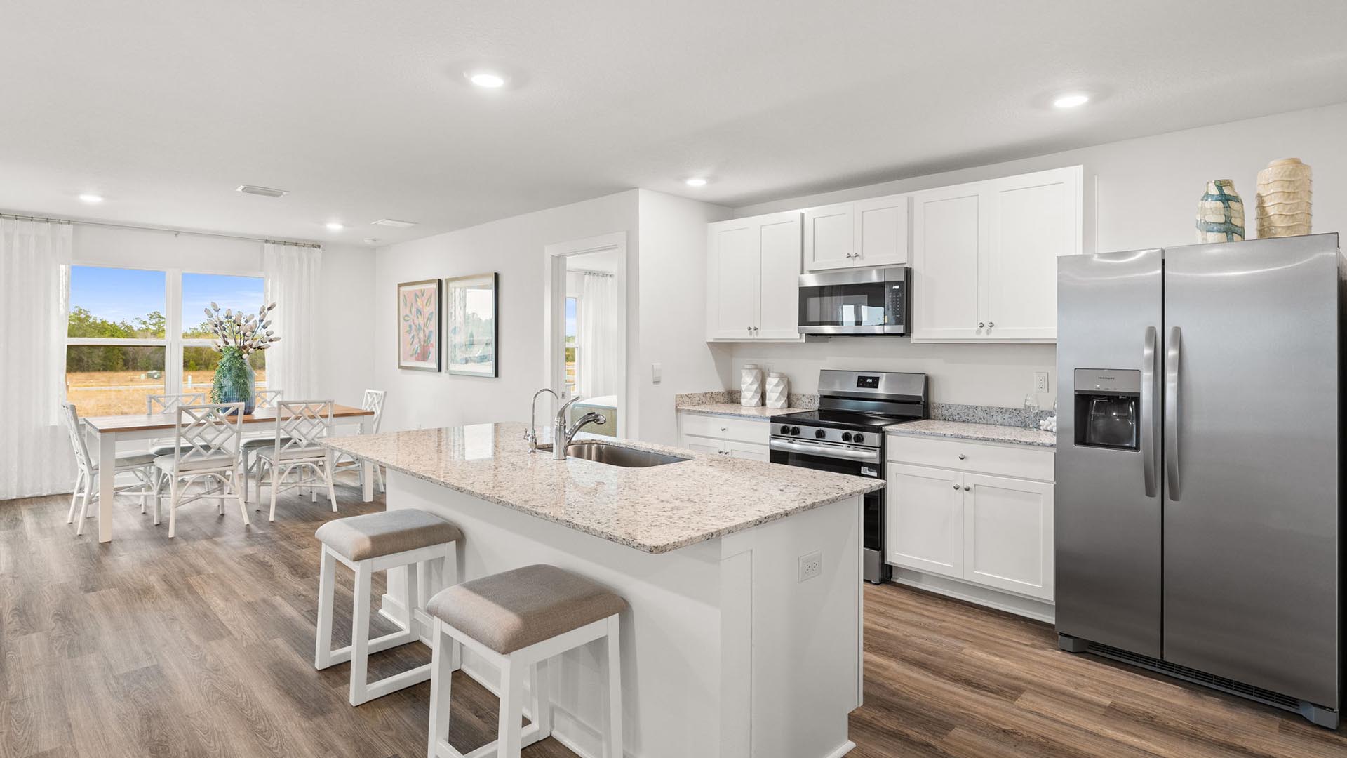 This image shows the staged model home and the kitchen with a center island