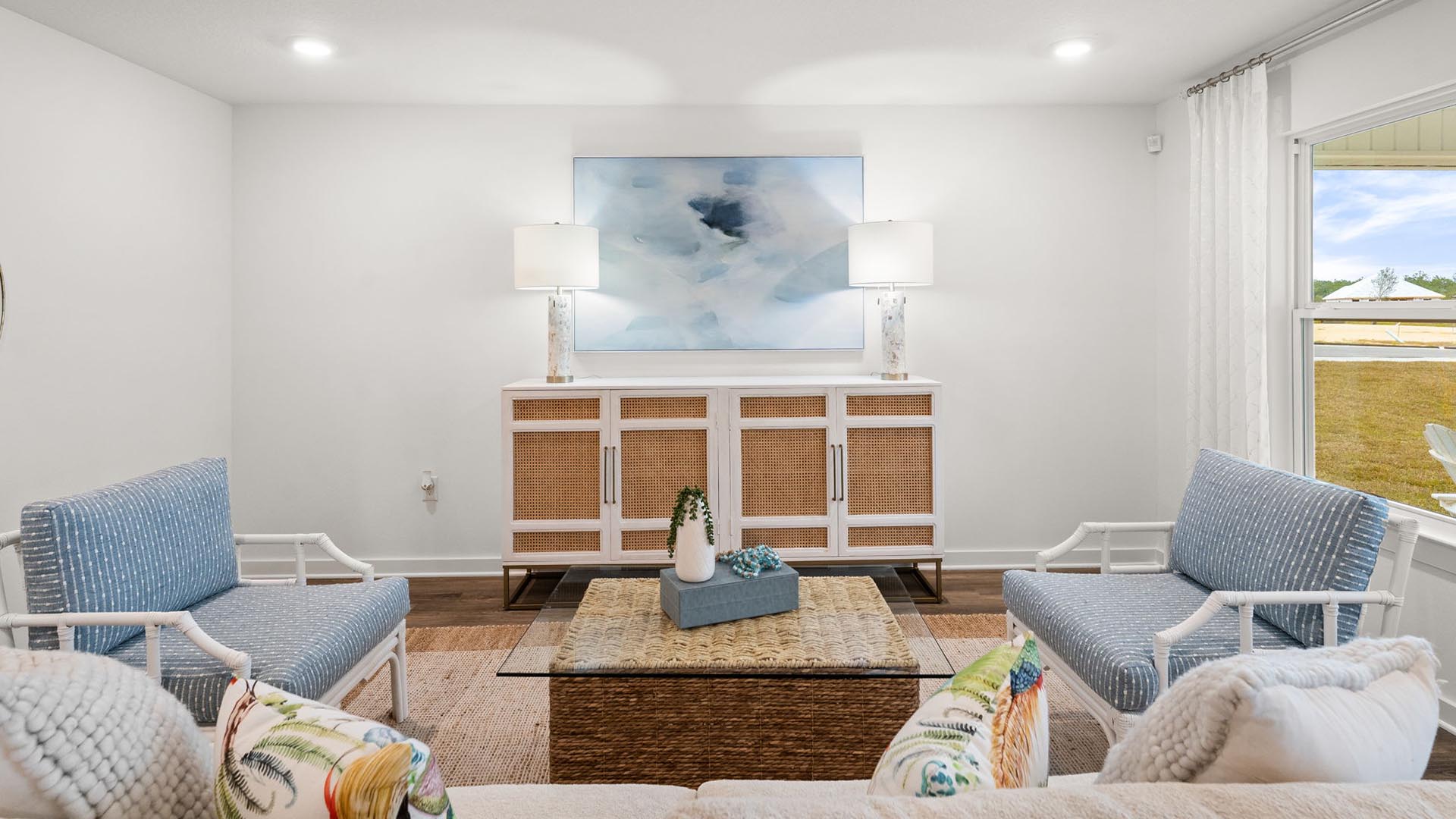 The living area is brightly lit by the windows