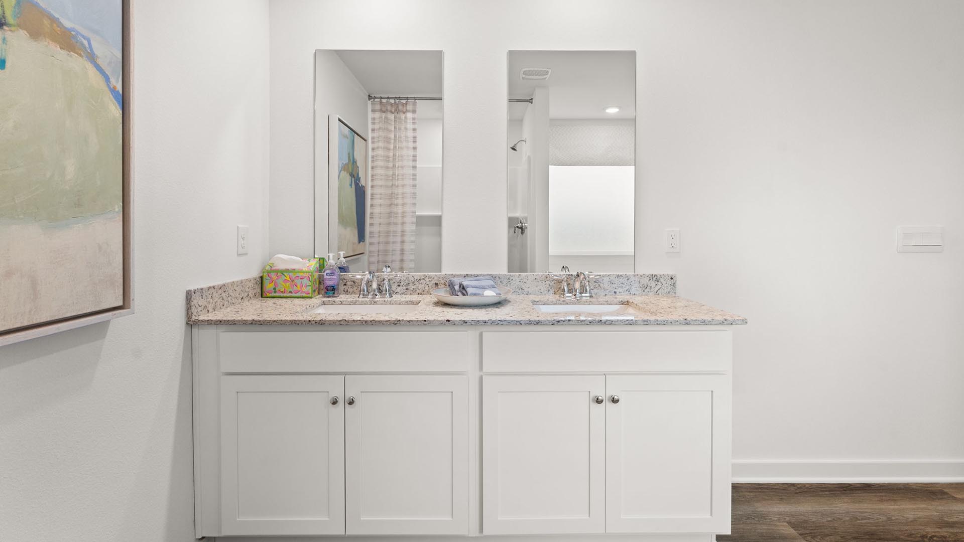 The primary bathroom has a dual sink vanity with lower cabinetry for storage