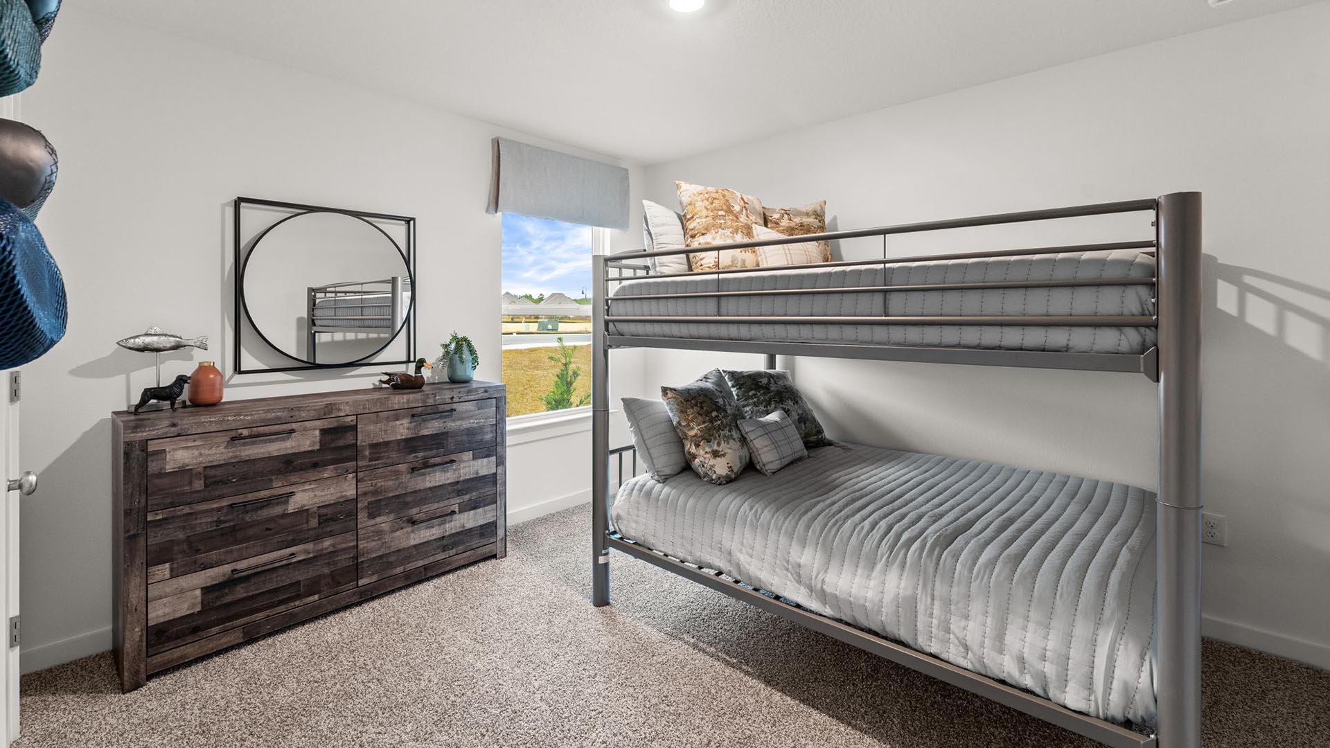 There are two guest bedrooms. This image shows a furnished bedroom with bunk beds and a dresser