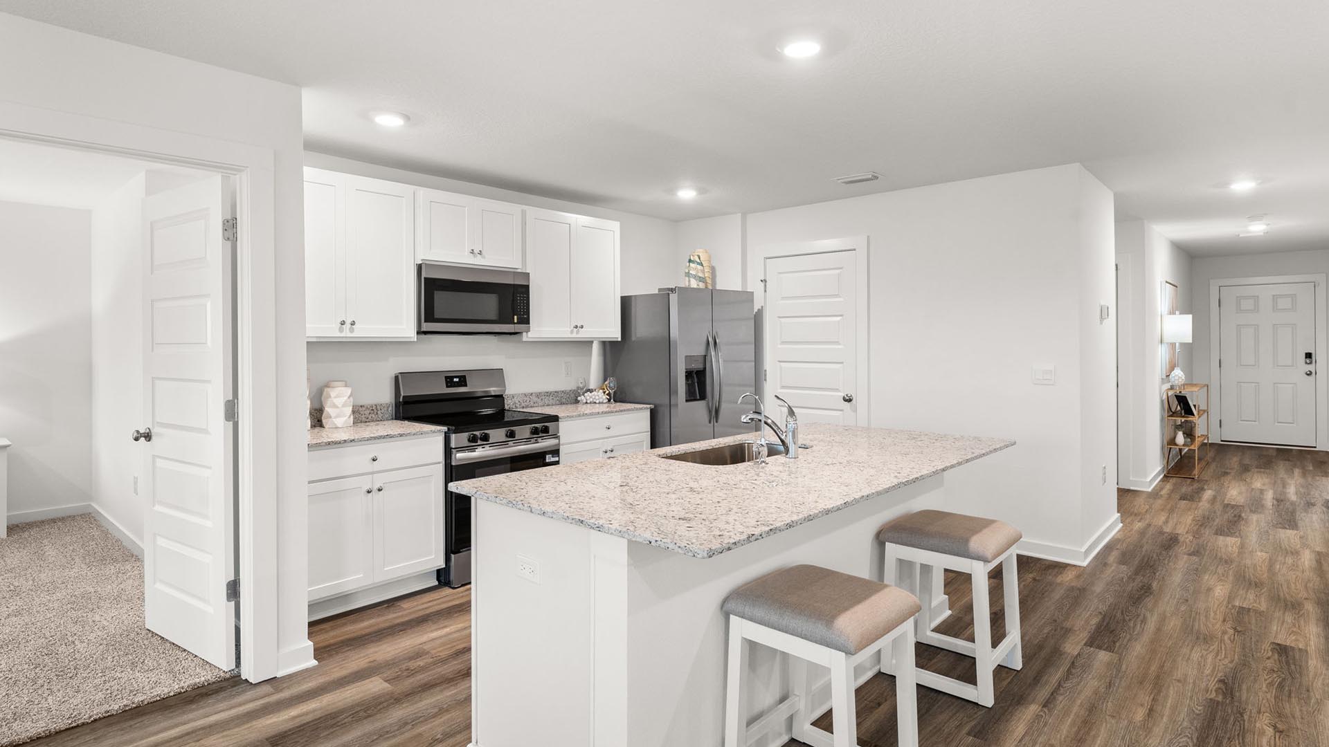 The center island has granite countertops and space for bar seating