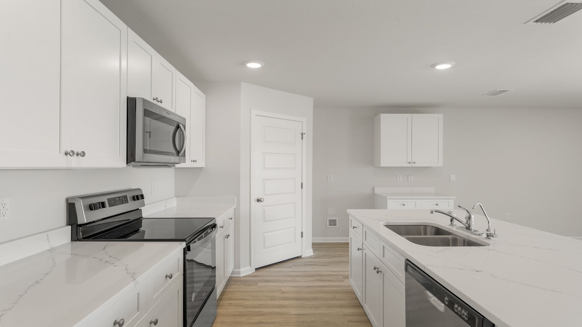 The kitchen has upper and lower cabinetry for storage