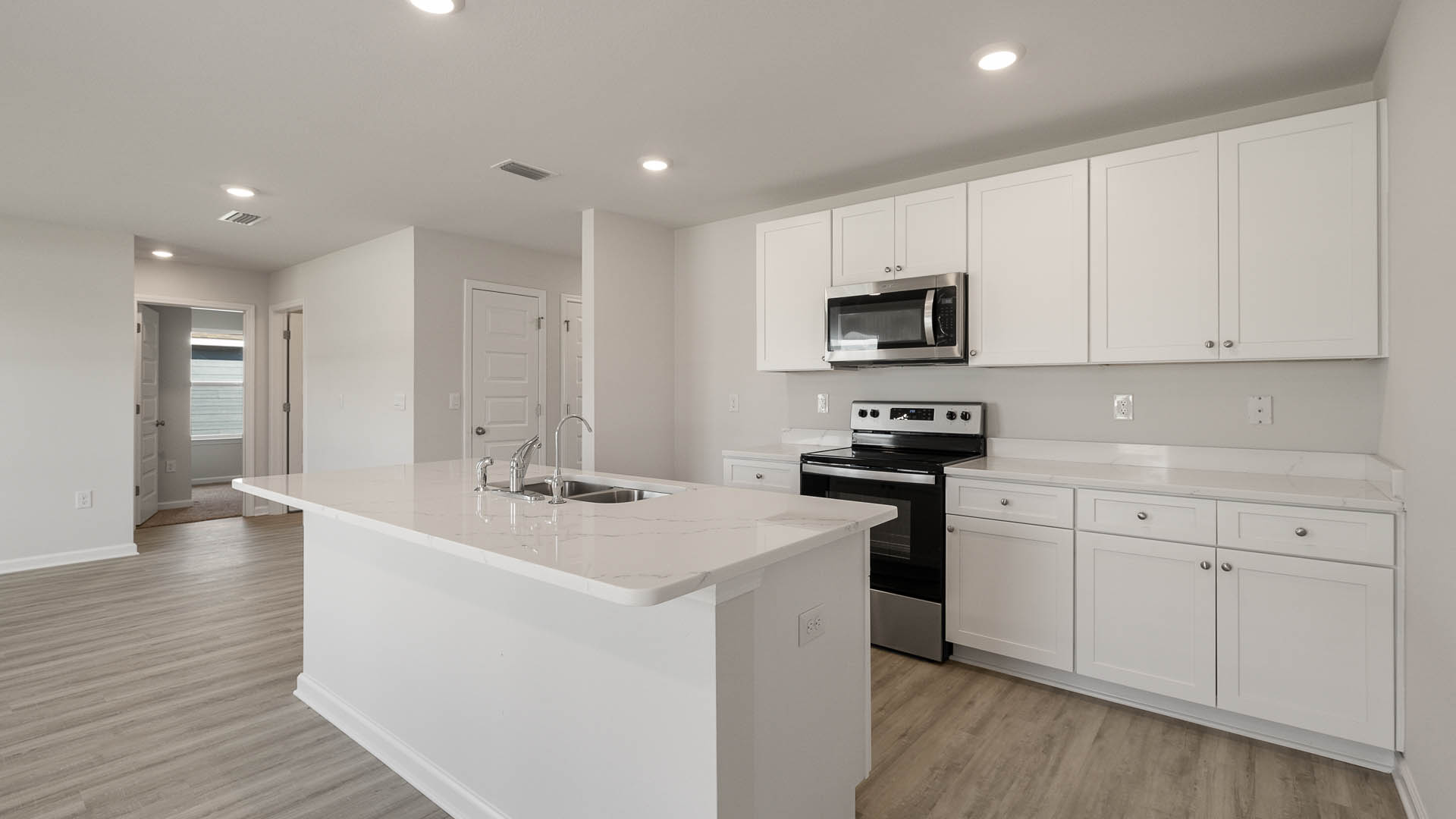 The kitchen features quartz countertops and upper and lower cabinetry for storage