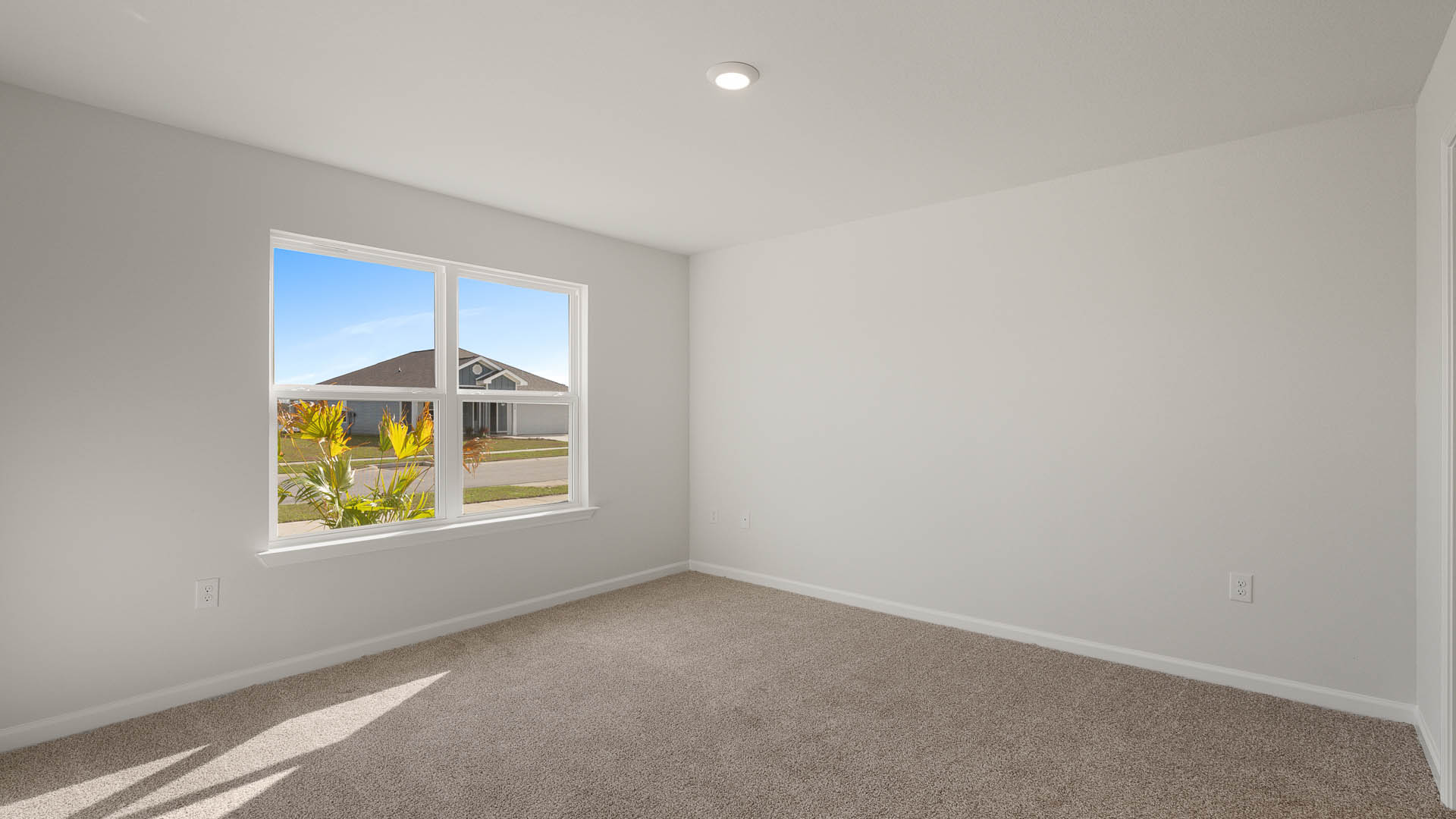 The primary bedroom has carpet and a large picture window for natural light