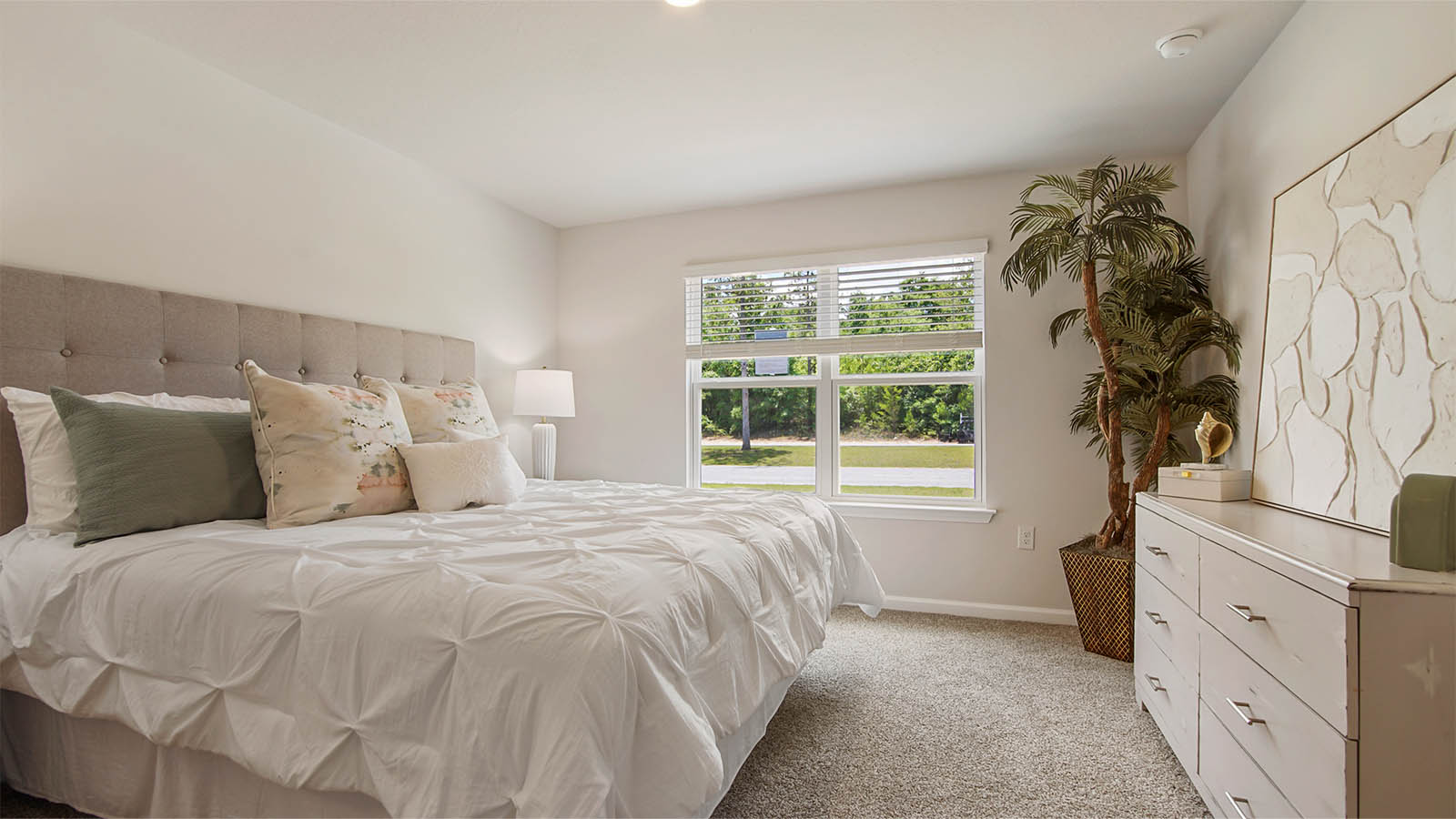 The primary bedroom has carpet and a large picture window