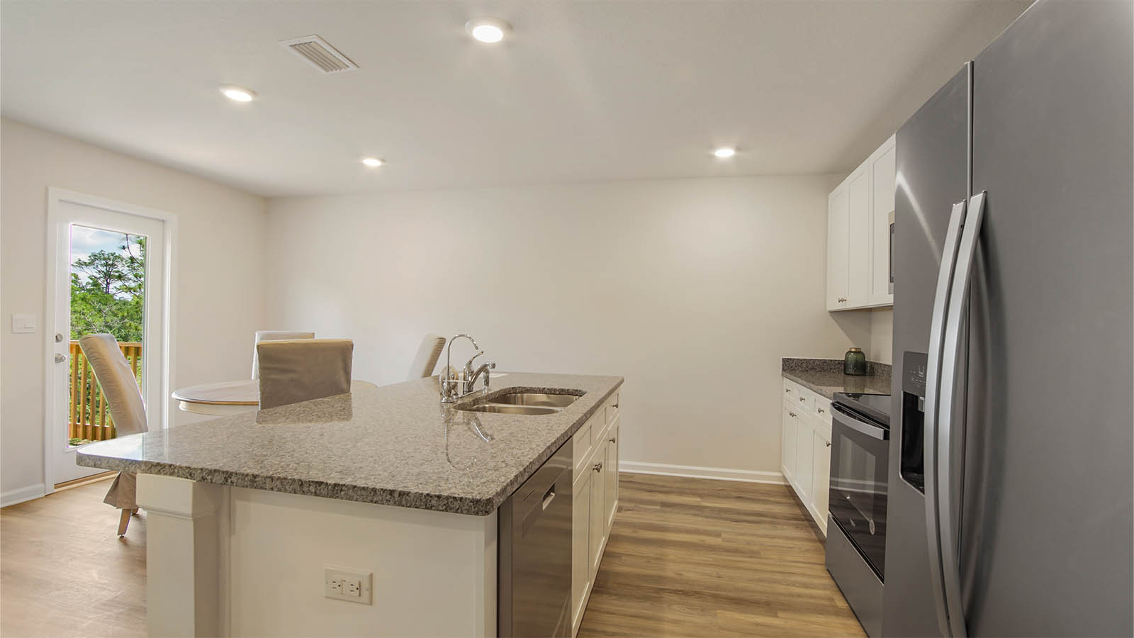 The kitchen has stainless appliances including a smooth top stove