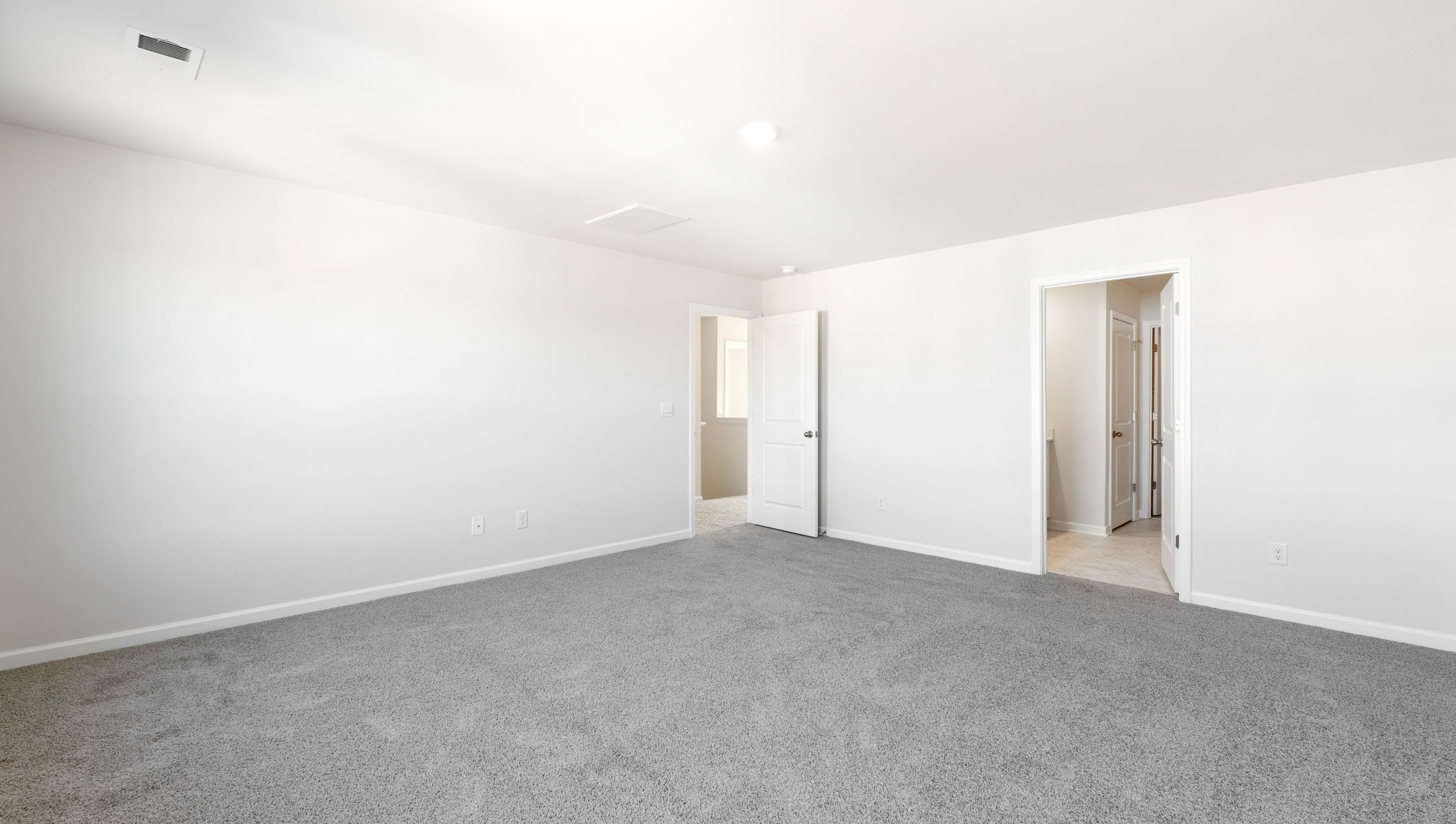 The primary bedroom is spacious and has a private ensuite bathroom