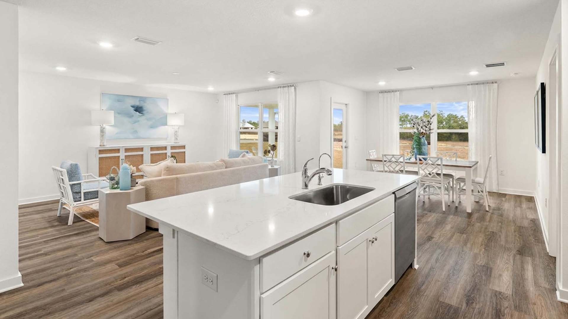 This image shows the staged model home and the kitchen with a center island