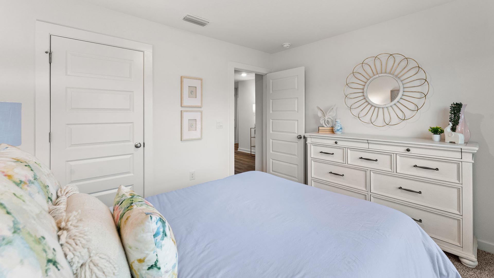 This image shows the guest bedroom with a full size bed and dresser. The guest bedroom has carpet and ample closet space.