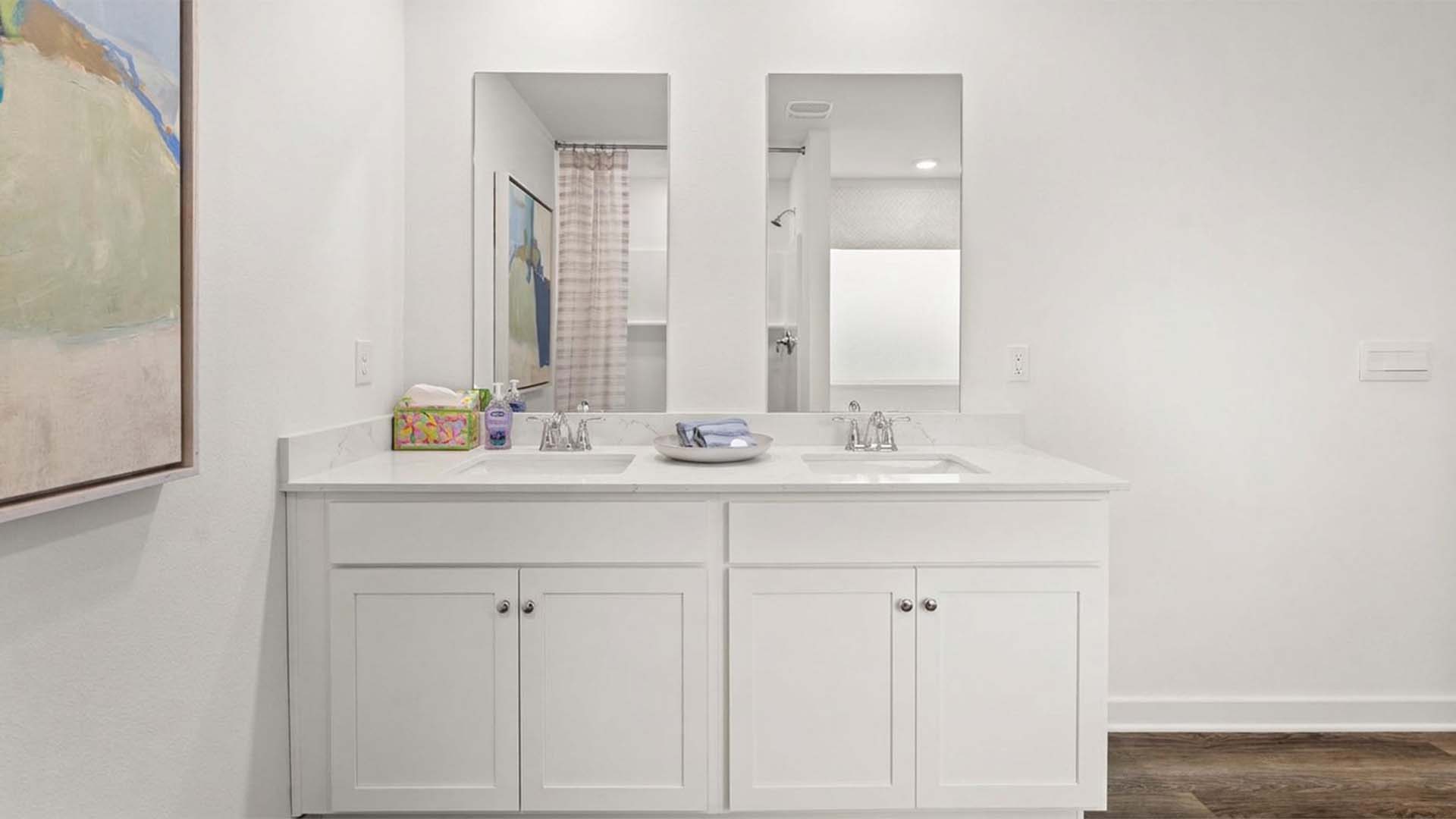 The primary bathroom has a dual sink vanity with lower cabinetry for storage