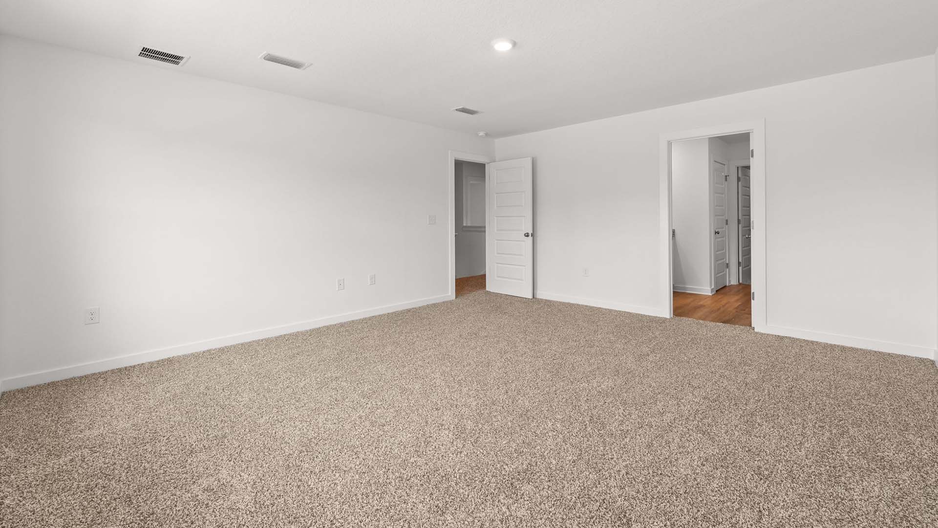 The primary bedroom is spacious and has a private ensuite bathroom