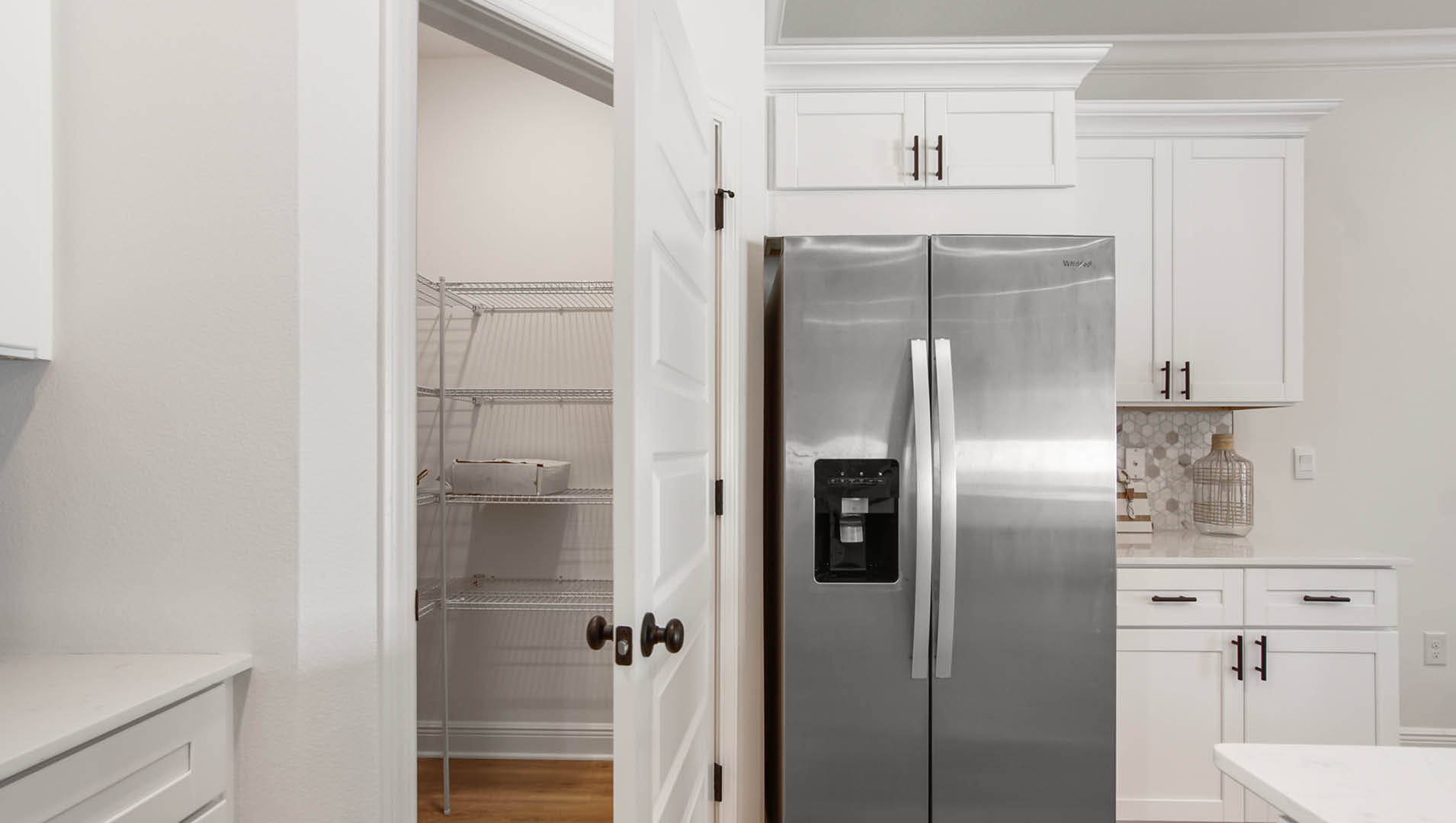 The kitchen features a corner pantry with ventilated shelving for your grocery and appliance storage needs