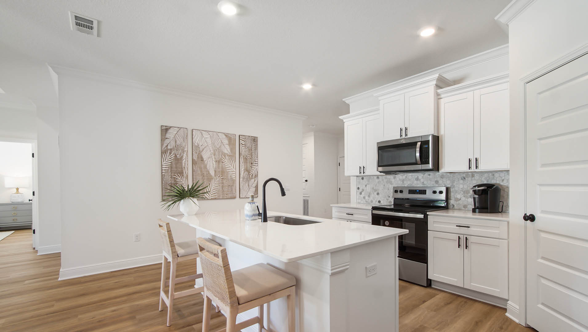 The center island has space for bar seating. The kitchen is also equipped with stainless appliances featuring a smooth top stove microwave and dishwasher