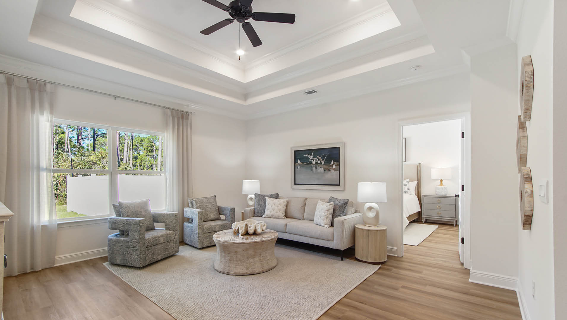 The open living area features trey ceilings and EVP flooring as well as an overhead fan