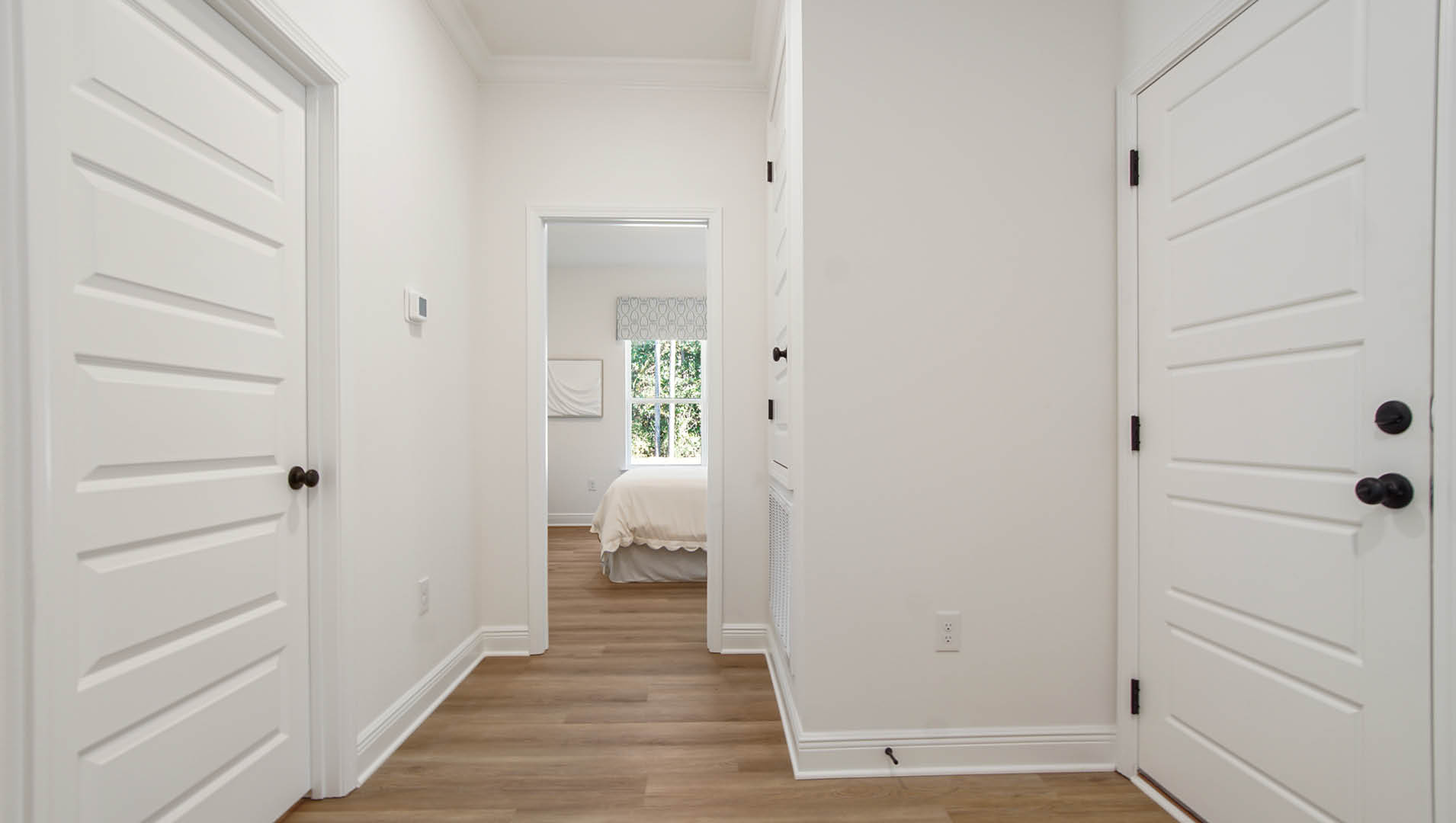 The fourth bedroom is located off a hall that leads to the garage and laundry room