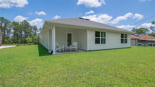 Covered porch at the rear of home is accessible from the dining room