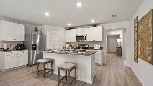 Spacious kitchen features upper and lower cabinetry and stainless appliances including a stove microwave and dishwasher