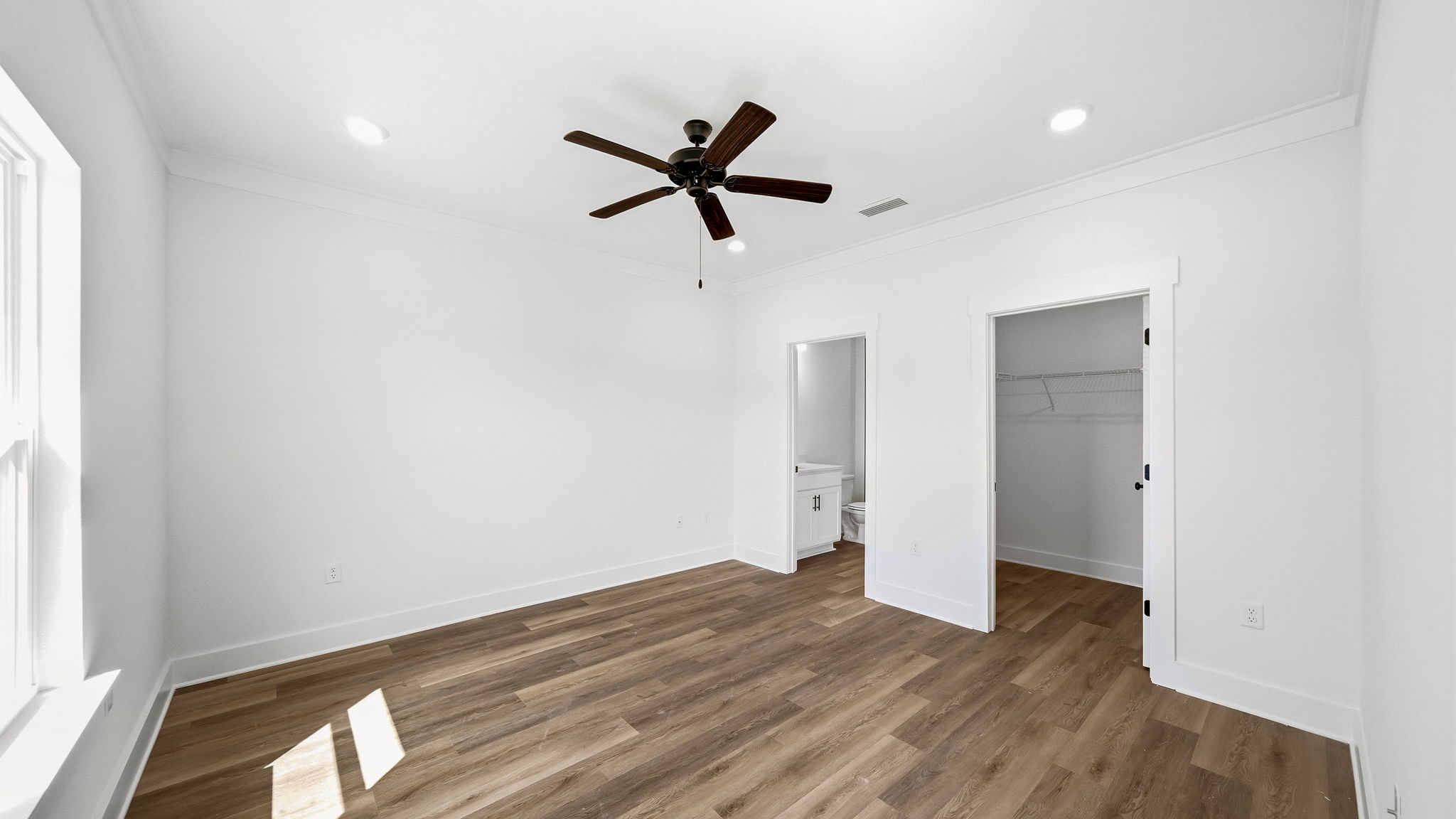 Primary bedroom with EVP flooring and overhead fan