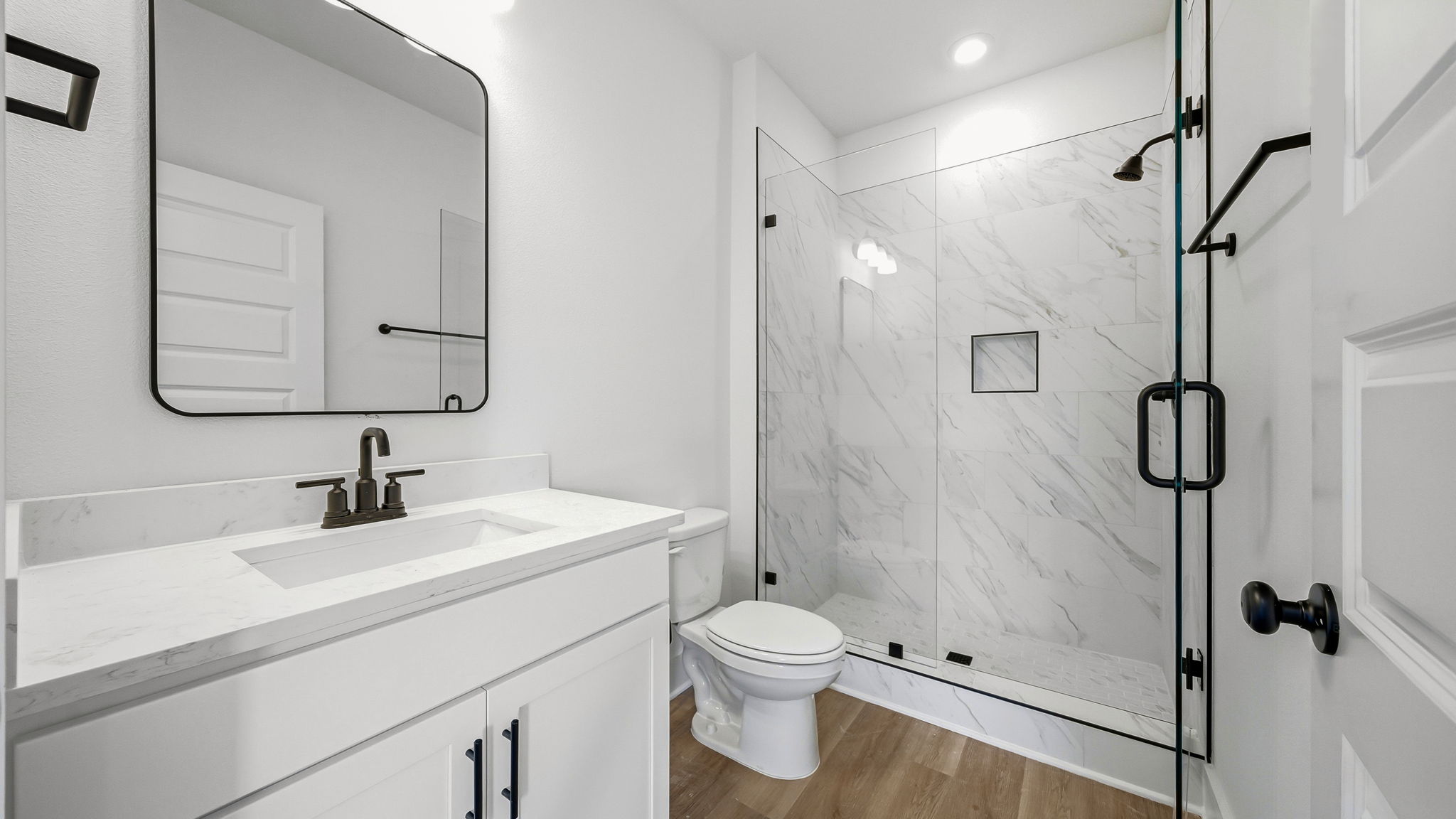 The primary bathroom has a shower and a single vanity with lower cabinetry