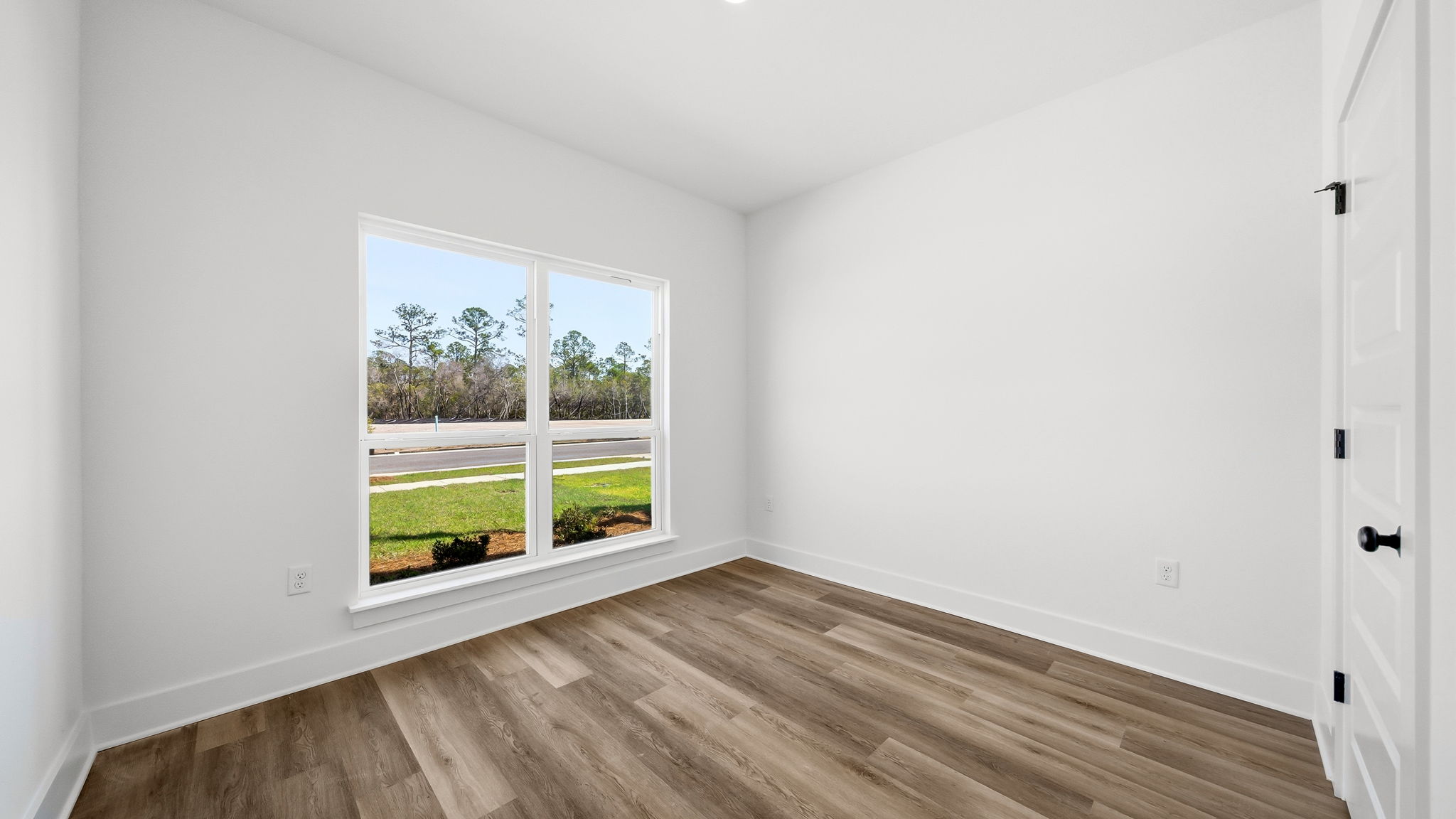 Guest bedroom one has EVP flooring is located at the front of the hom