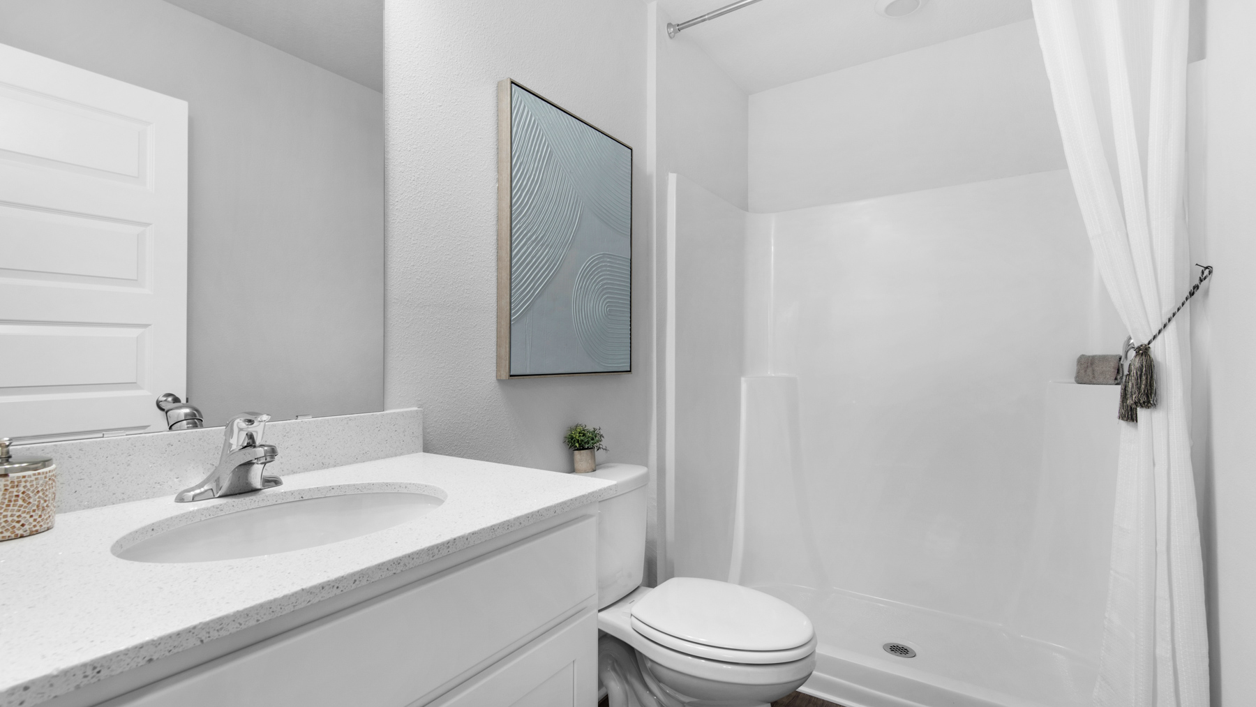 The primary bathroom has a shower and a single vanity with lower cabinetry