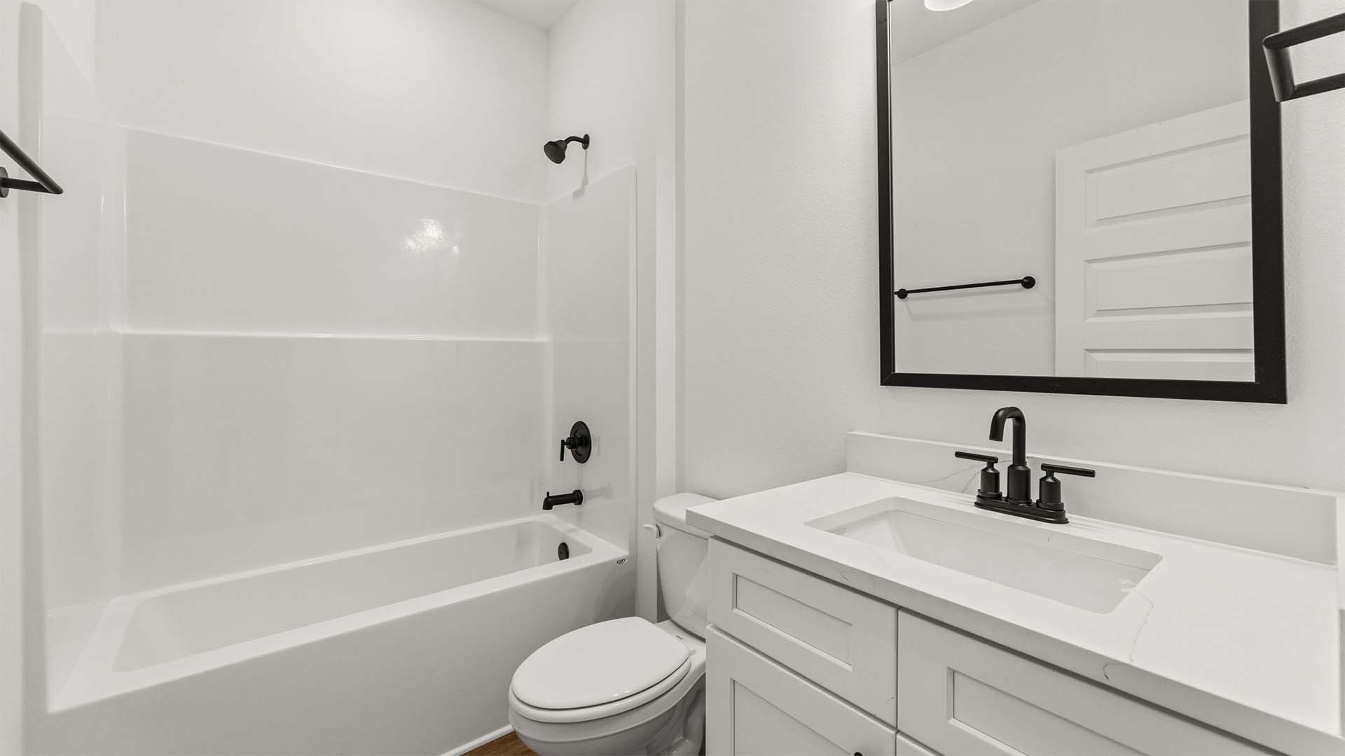 The shared bath has a single vanity and shower tub combination