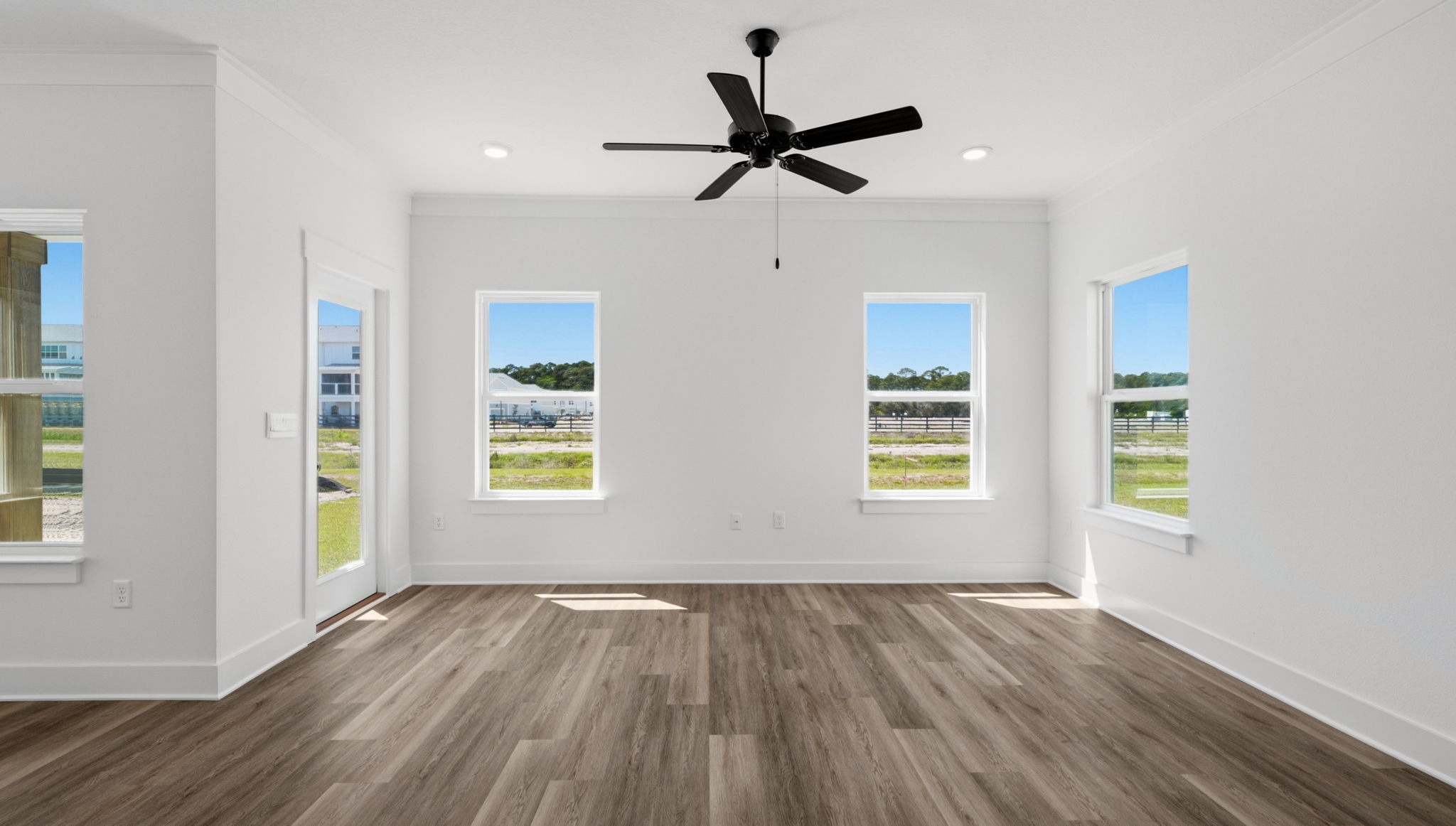 The living area has a ceiling fan and access to the back patio