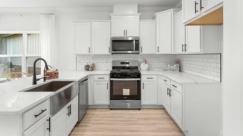 The kitchen has upper and lower cabinetry for storage