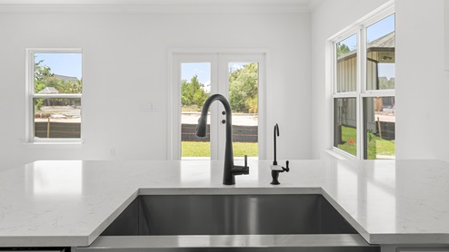 The stainless sink features black plumbing fixtures