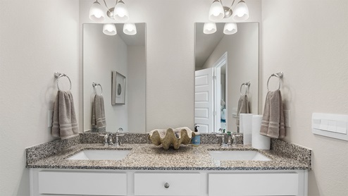 The primary bath has quartz countertops and a dual sink vanity