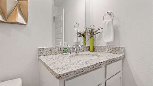 Shared bathroom with single vanity featuring granite countertops
