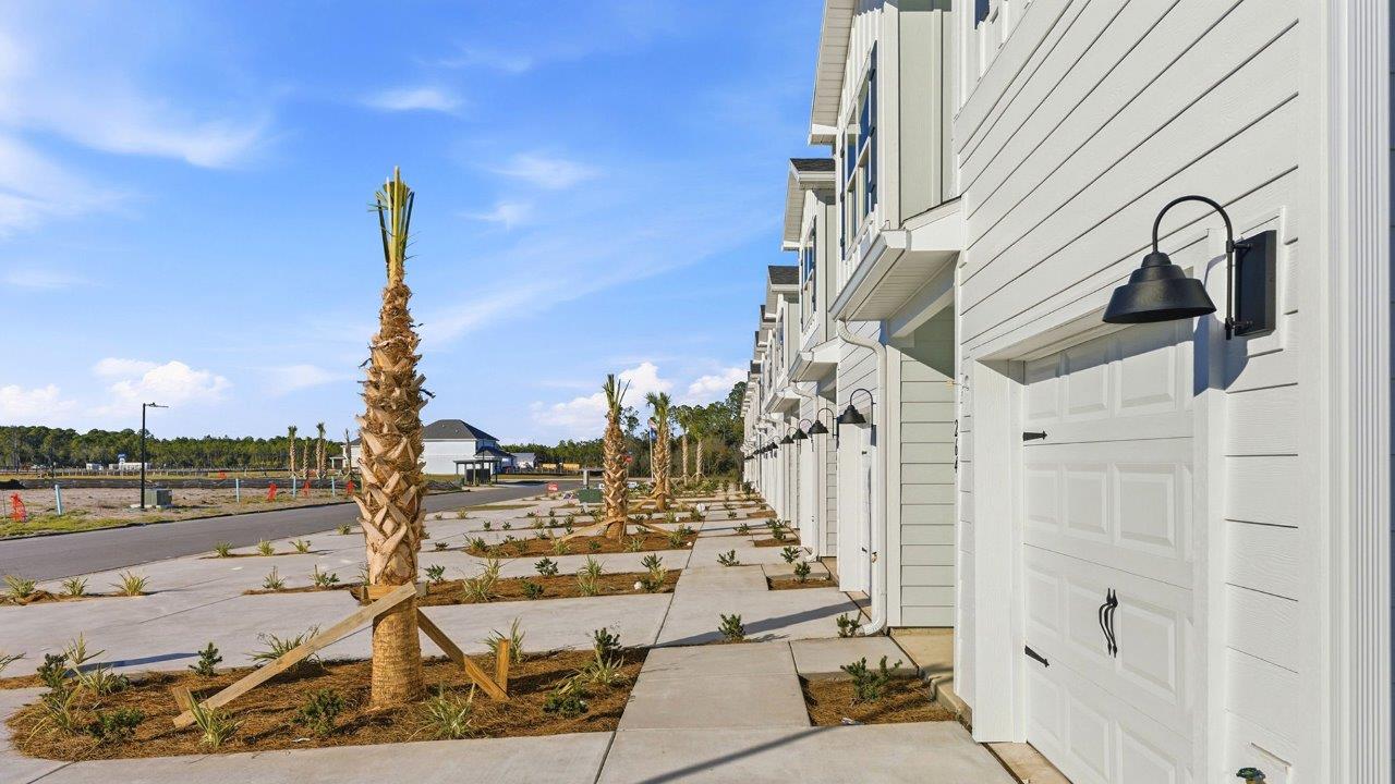 Each townhome front exterior includes landscaping along the driveway between unitis