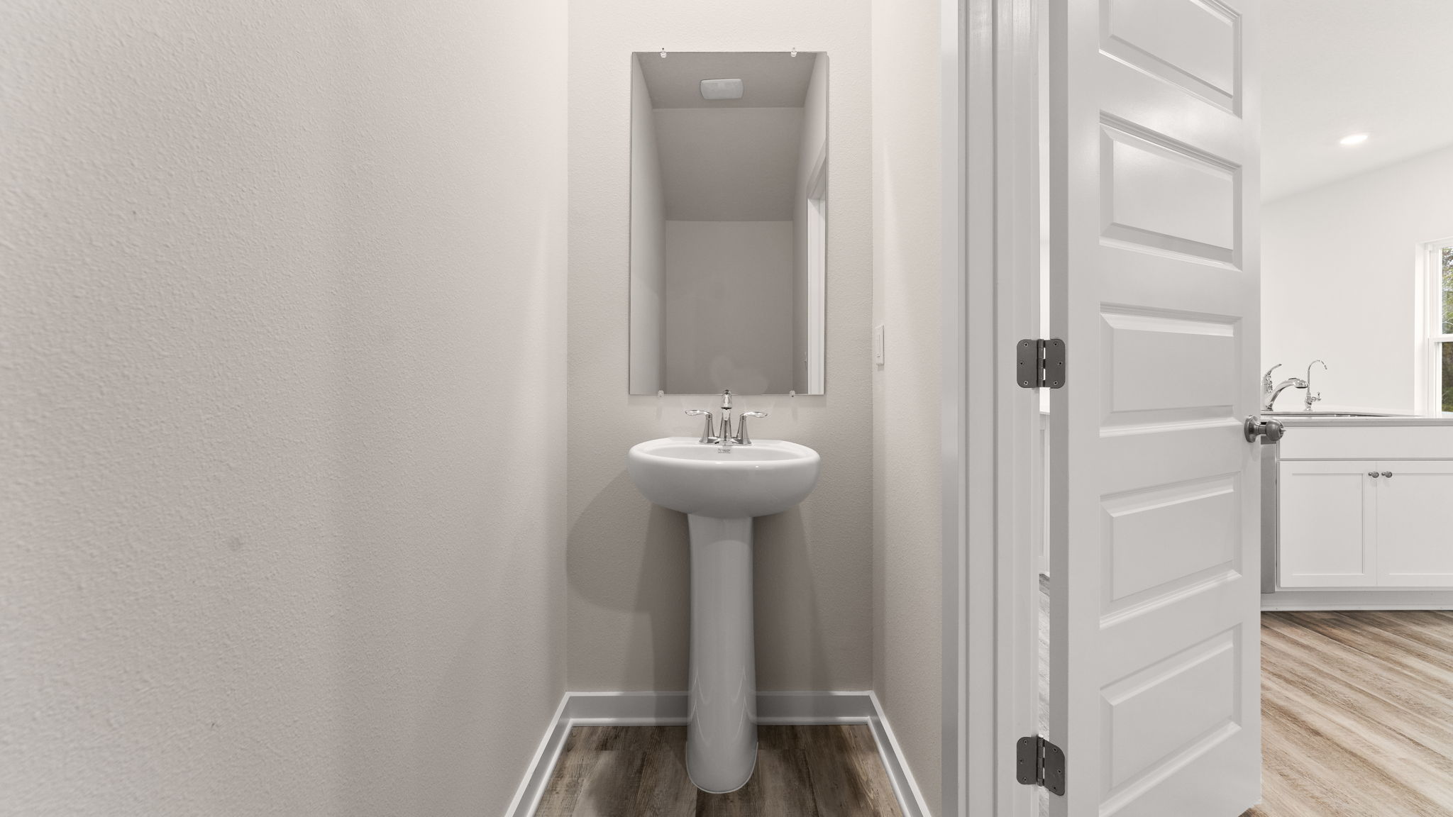 The half bathroom has a pedestal sink