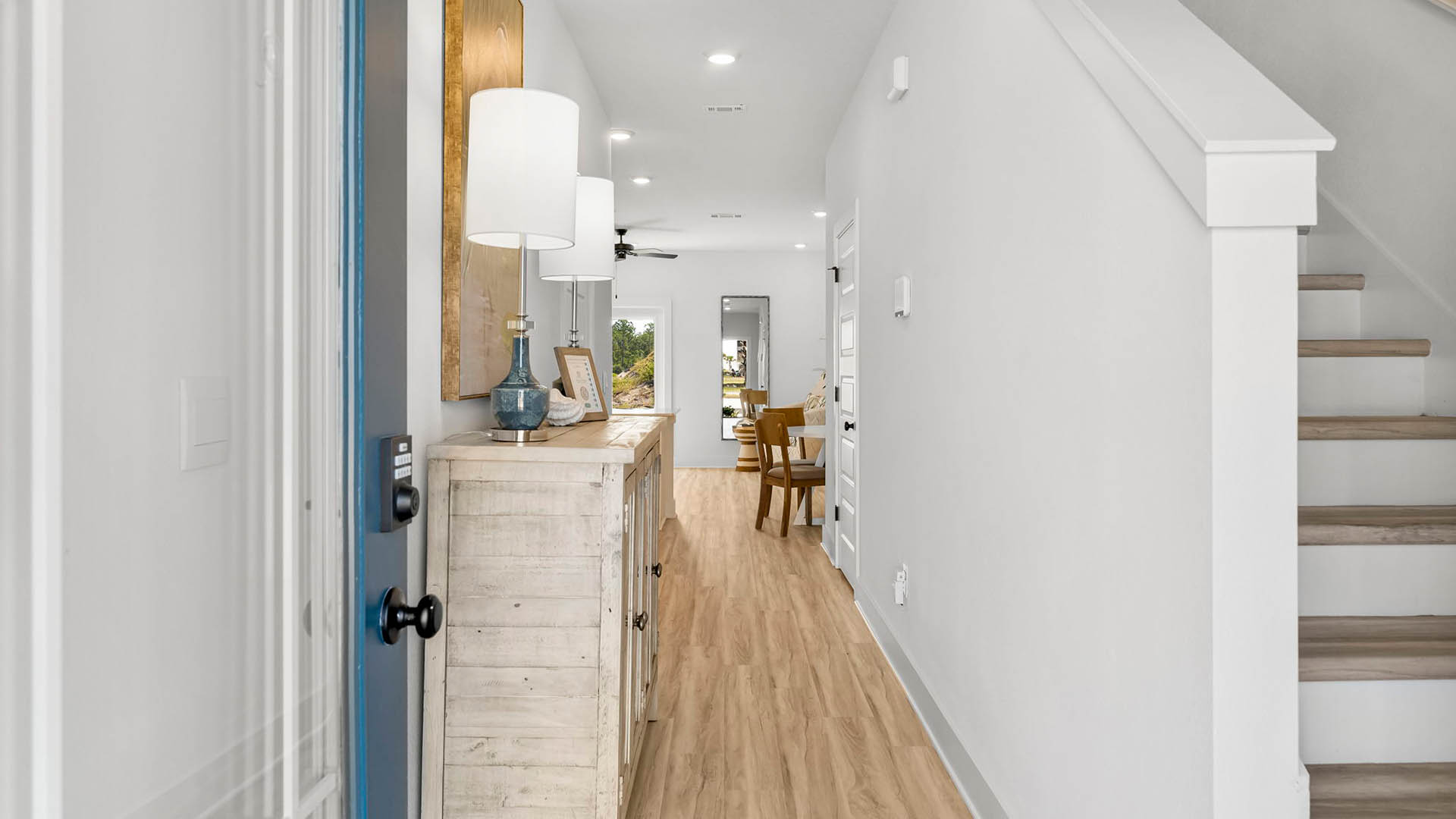 The entry hall is well lit and has stairs leading to the second level