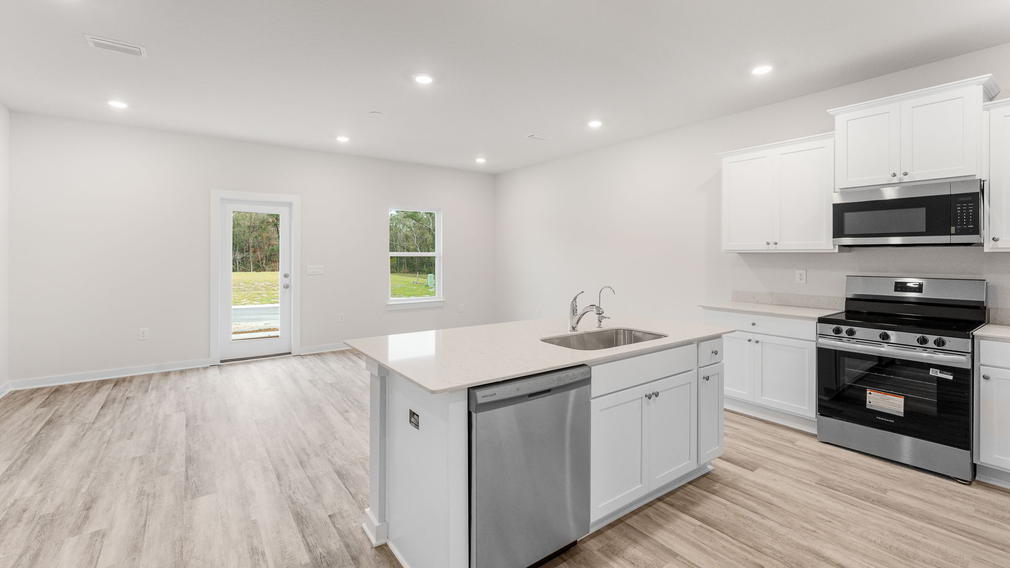The living area is open and spacious with EVP flooring and open kitchen