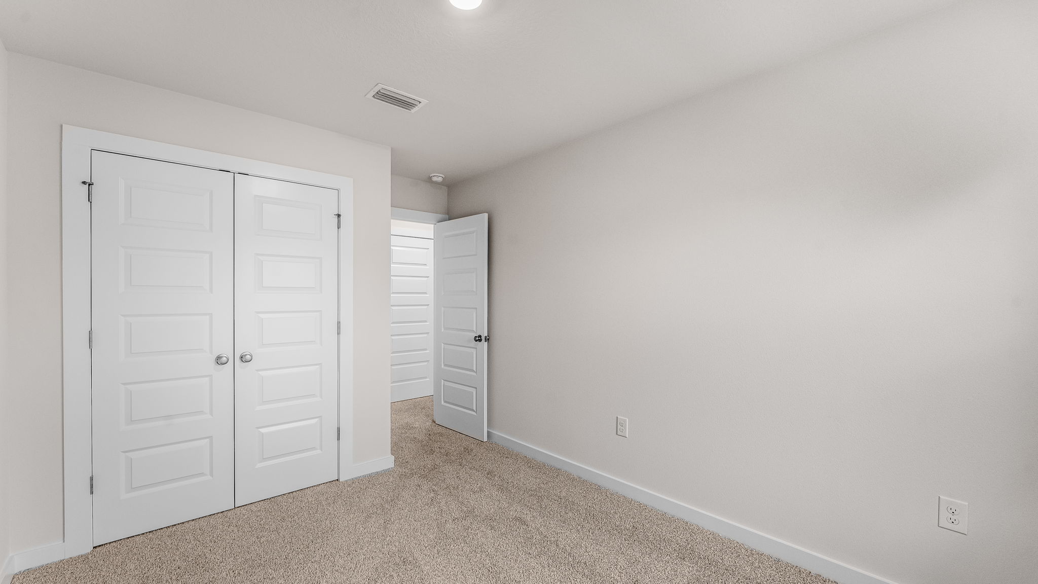 Guest bedroom two has carpet and ample closet space